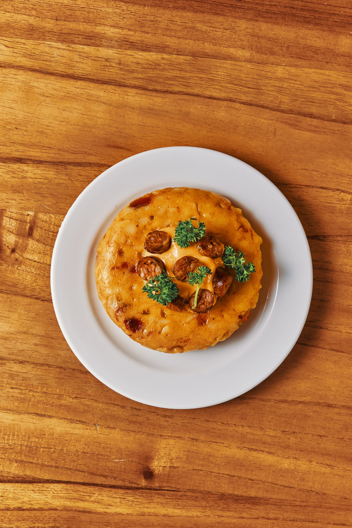 La tortilla de la casa sale babé con cebolla caramelizada, chistorra y morrones asados.