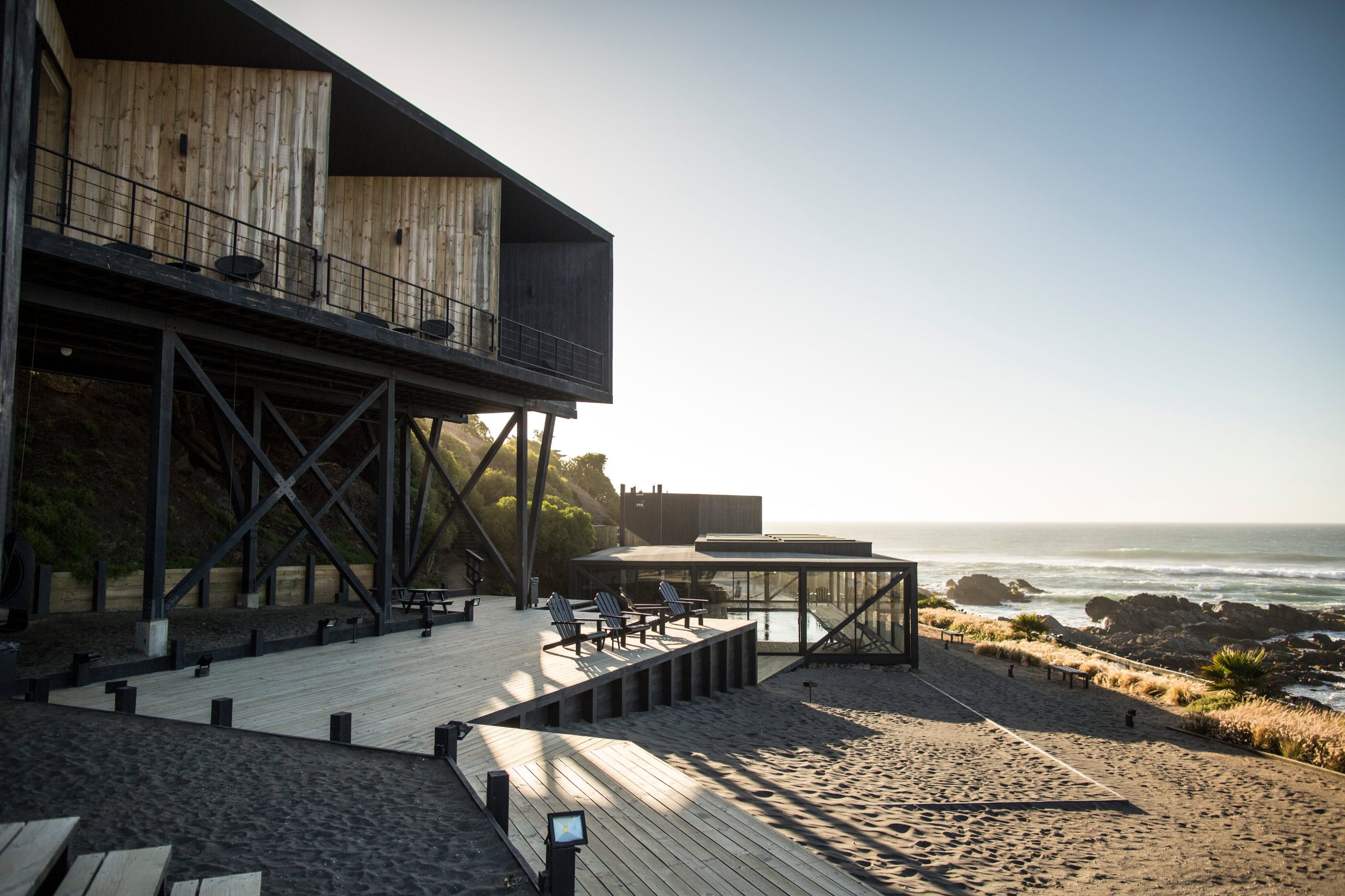 El hotel Puerto Viejo y su continuidad con el entorno mediante el deck, la piscina cubierta y hot tub al fondo.