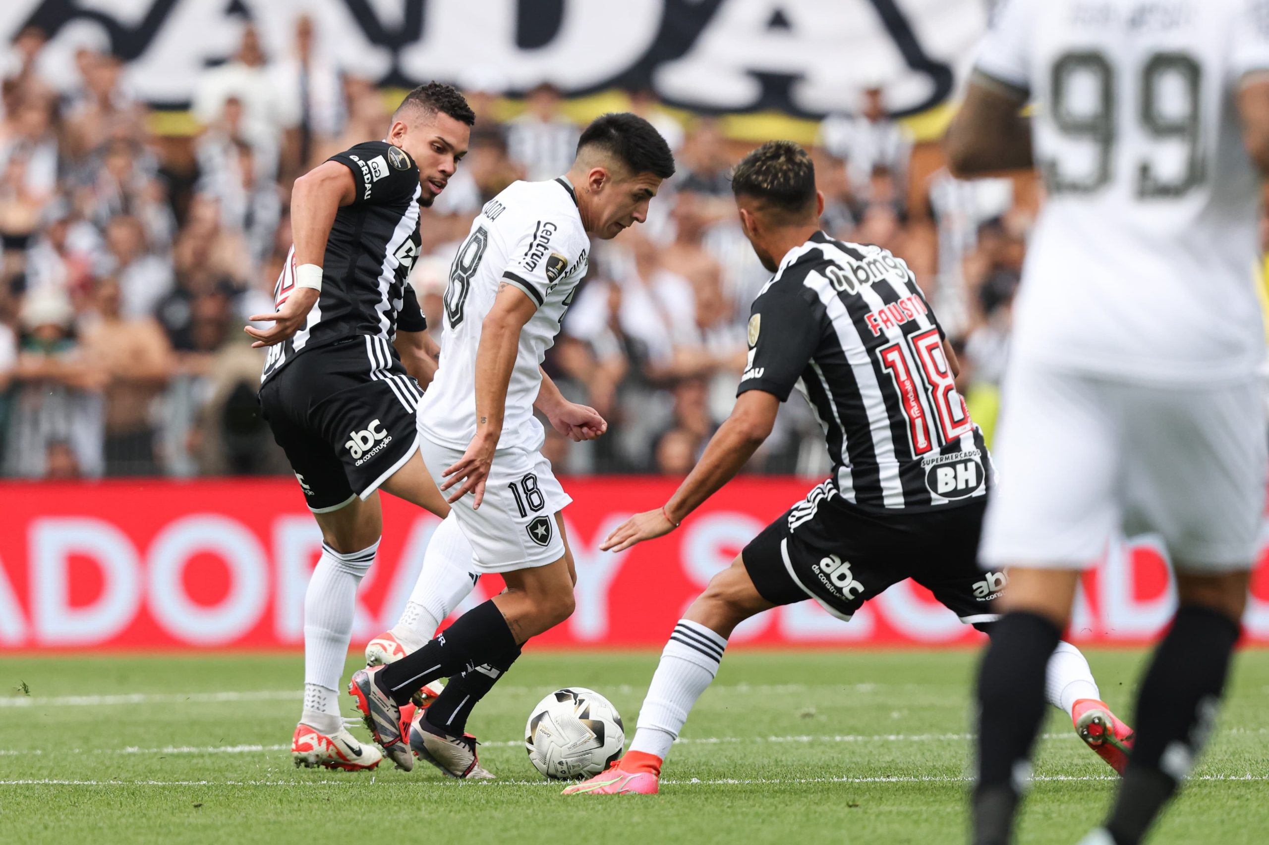 El argentino Thiago Almada maniobra ante la marca de dos jugadores de Mineiro