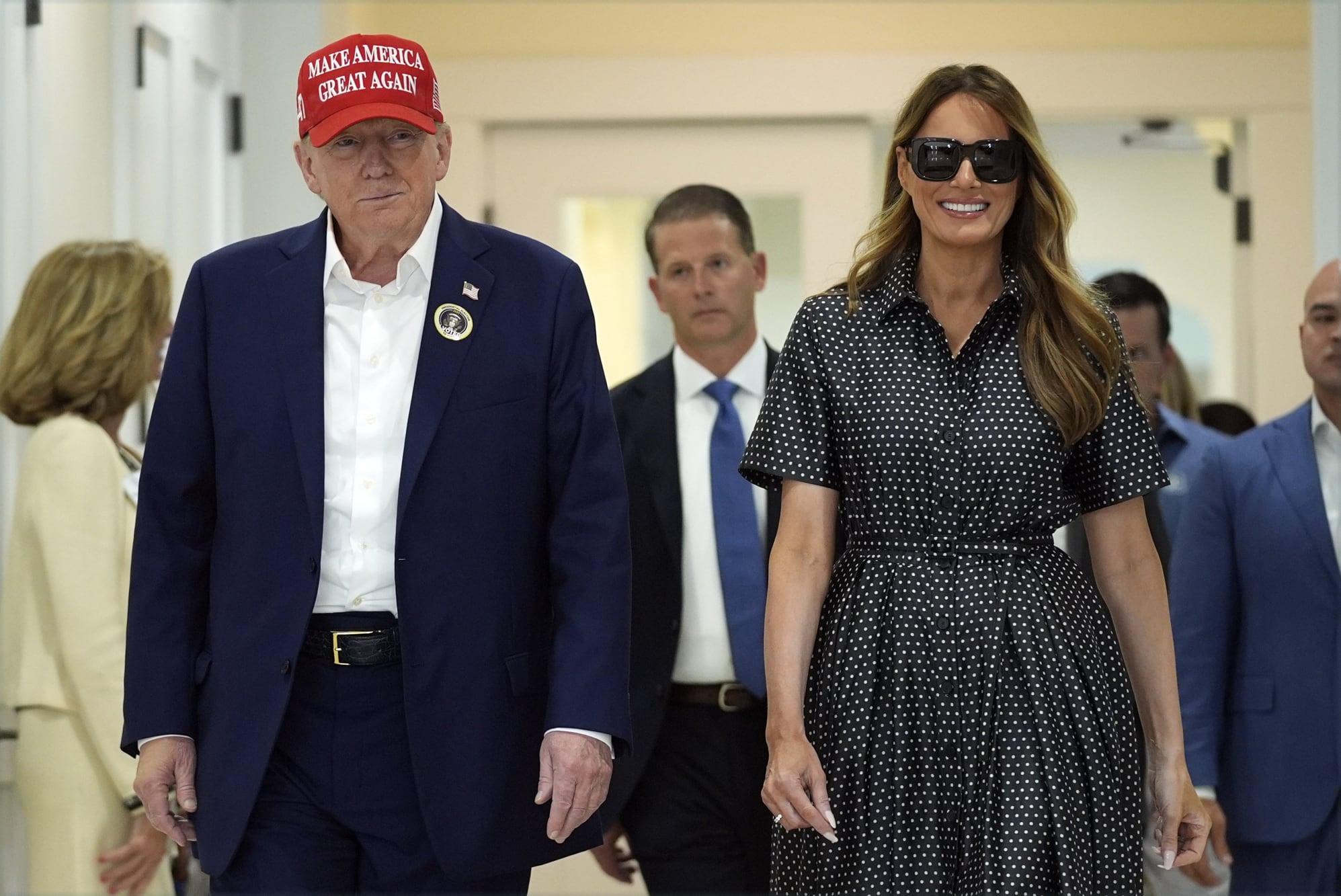 El candidato presidencial republicano, el expresidente Donald Trump, y la exprimera dama Melania Trump caminan después de votar el día de las elecciones en el Centro Recreativo Morton y Barbara Mandel, el martes 5 de noviembre de 2024, en Palm Beach