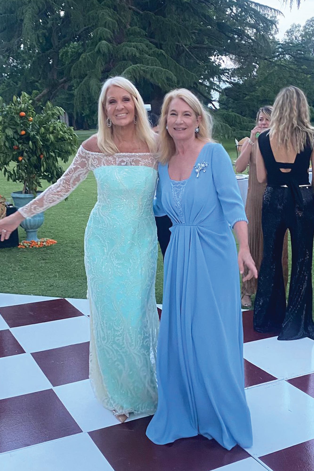 Las madrinas en la pista de baile. Evelyn Scheidl con un vestido en crêpe aguamarina de Claudio Cosano bordado con perlas y cristales, y María Taquini de Blaquier con un traje de Gabriel Lage en crêpe marroquí alforzado en la cintura que acompañó con un impactante broche de platino y brillantes, a juego con los aros. 