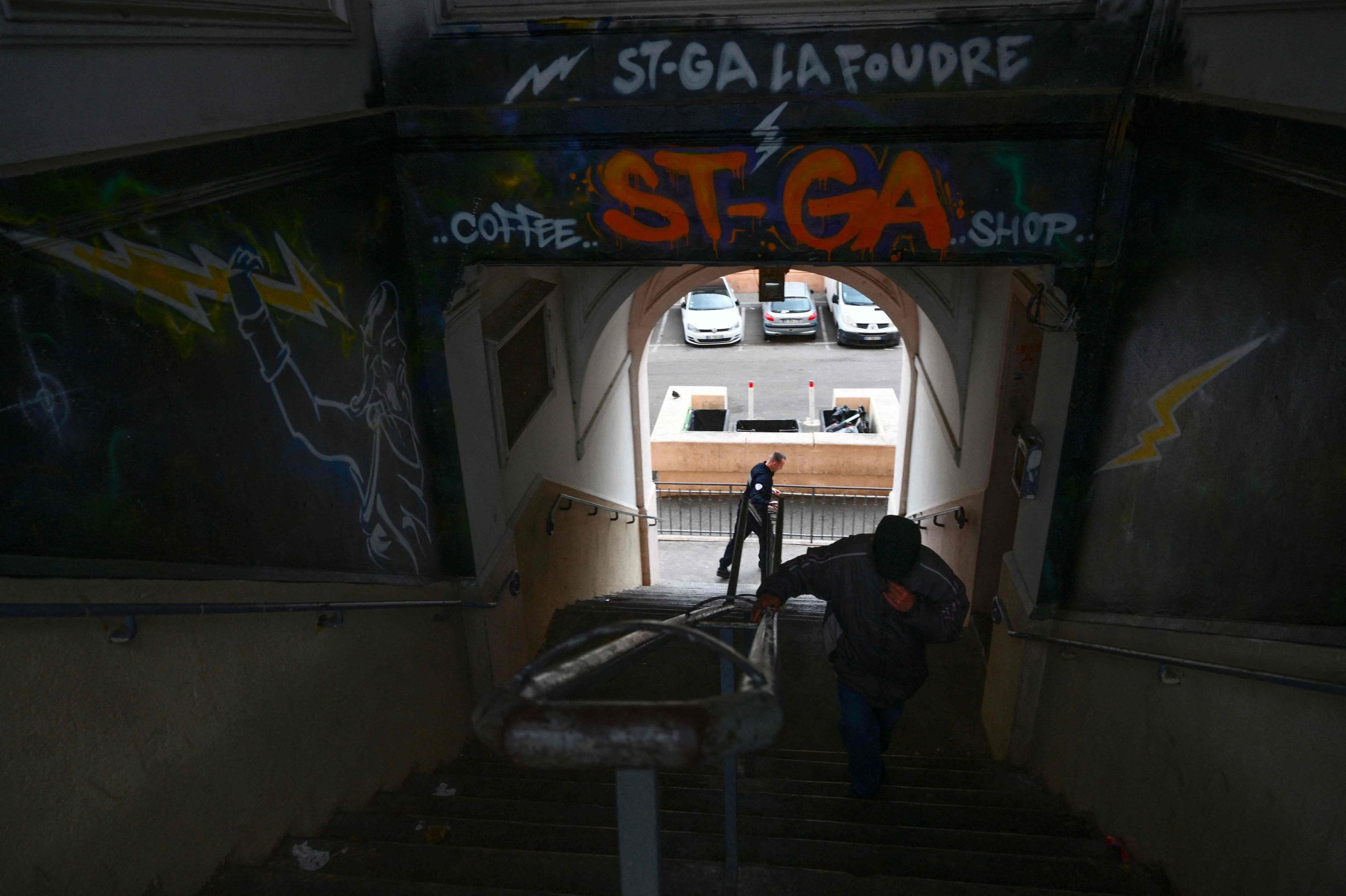 Un policía (izq.) patrulla cerca de una escalera en busca de presuntos traficantes en el distrito norte de Marsella, sur de Francia. 