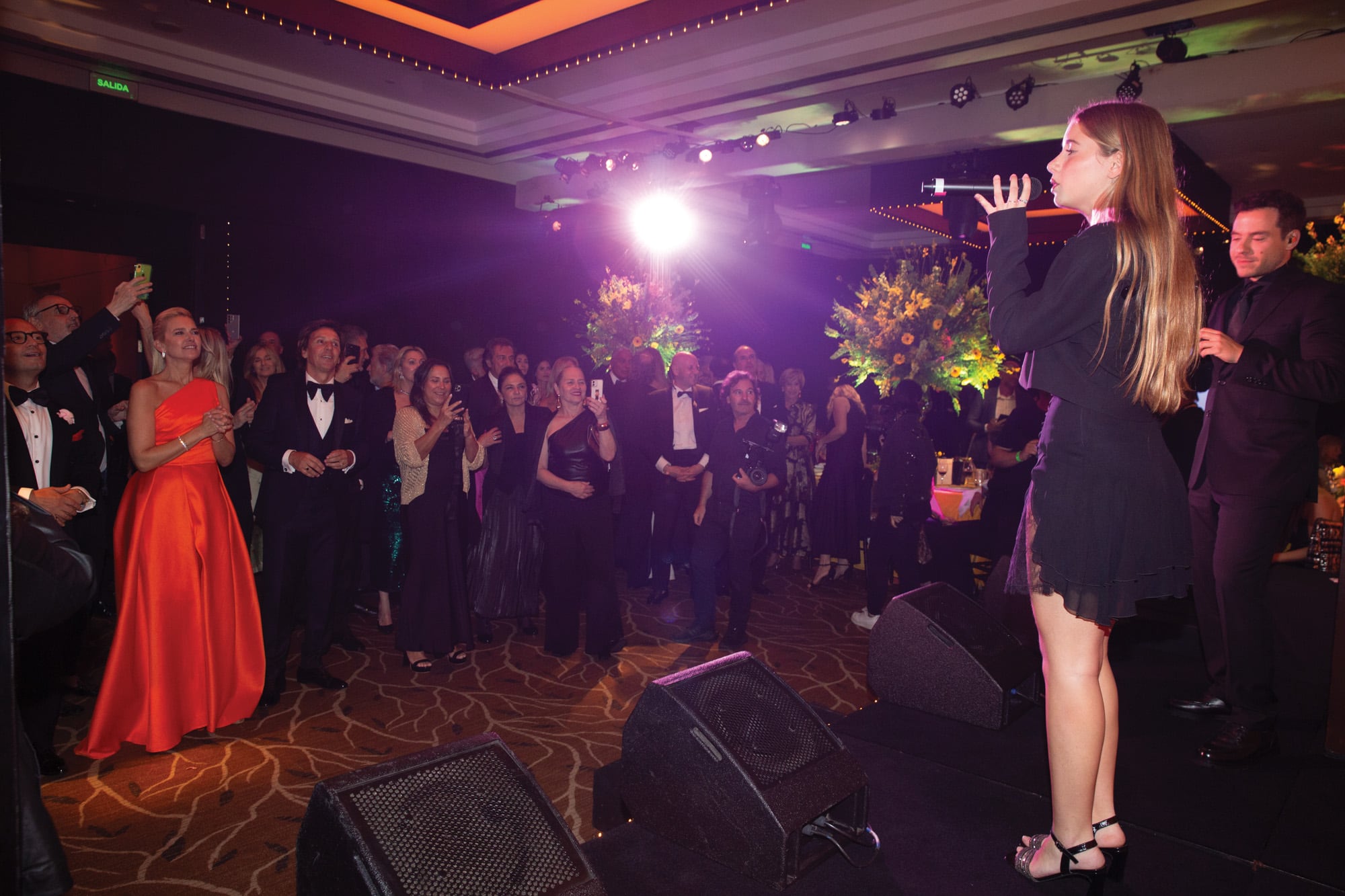 La empresaria –que se destacó entre la multitud por el color vibrante de su vestido– no pudo ocultar su orgullo de madre al escuchar a su hija Taína cantando en el escenario junto a Fer Dente.