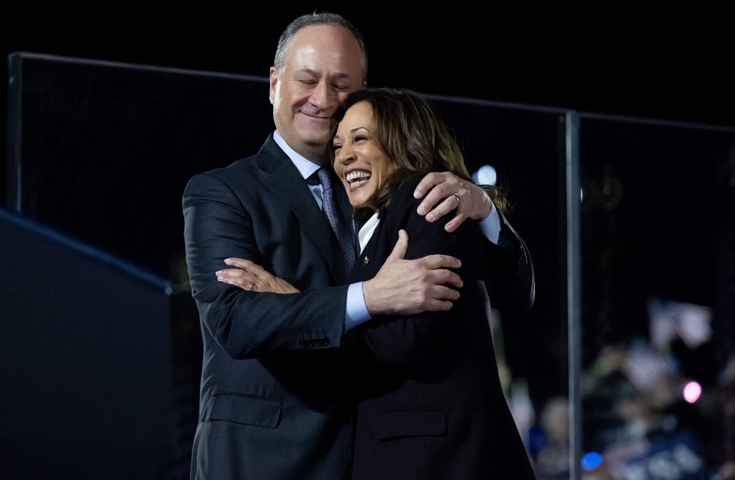 La vicepresidenta de Estados Unidos y candidata presidencial demócrata Kamala Harris es abrazada por su esposo, el segundo caballero Doug Emhoff