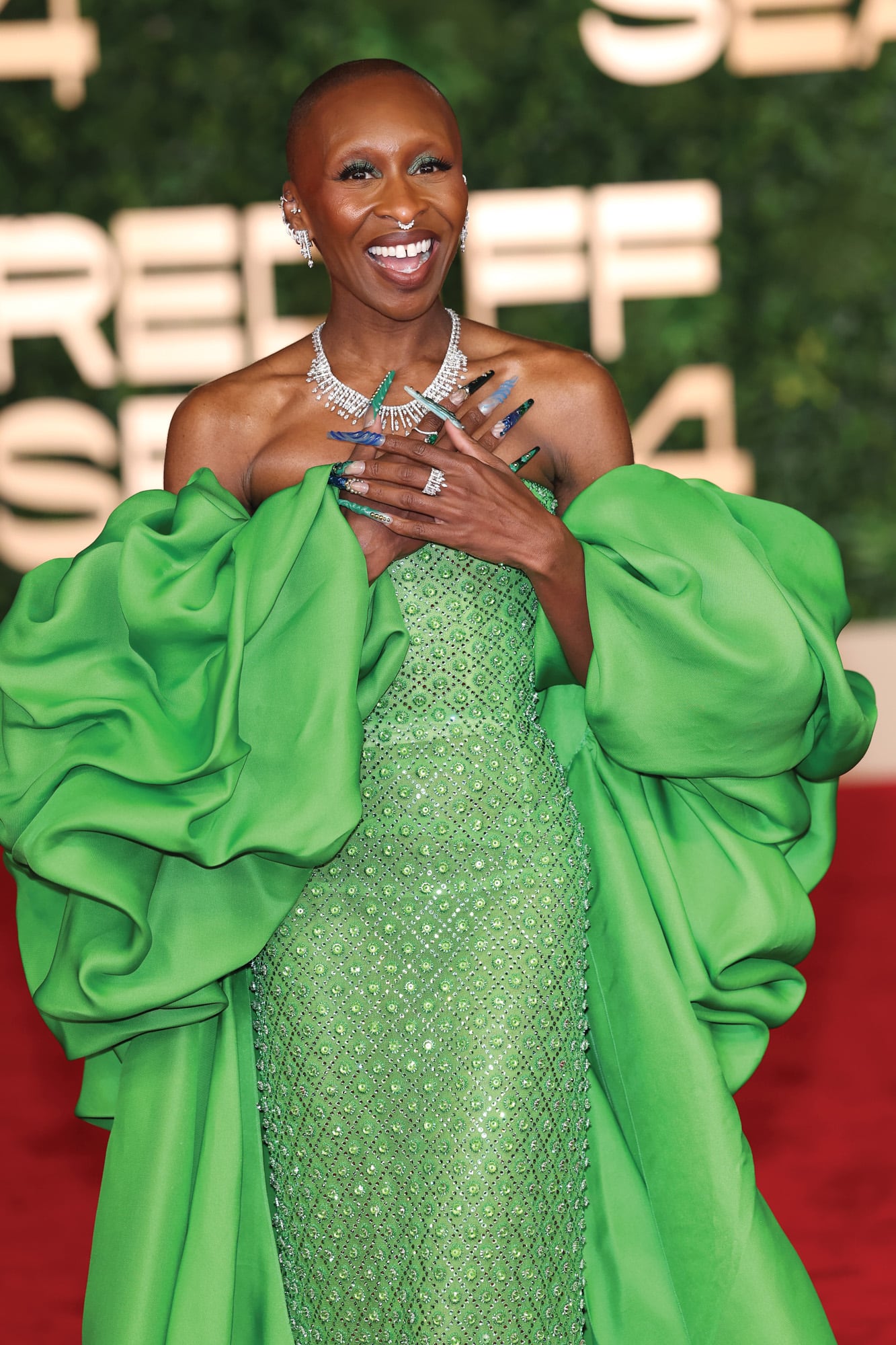 Cynthia Erivo con un vestido bordado en cristales de Carolina Herrera, con una voluminosa capa. El verde es el color del personaje que la actriz interpreta en Wicked.