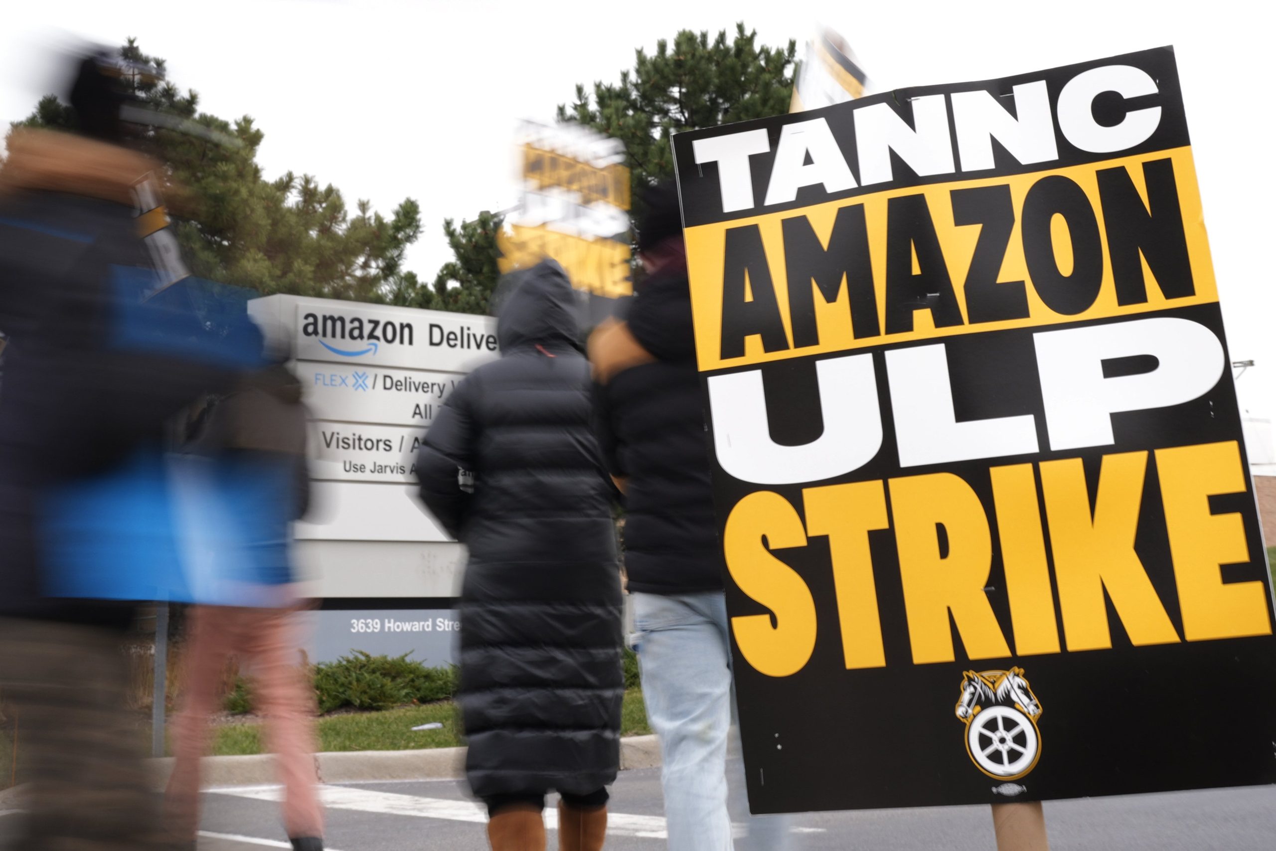 Los huelguistas sostienen carteles durante una huelga en la estación de entrega de Amazon de Skokie (DIL7) en Skokie, Illinois, el jueves 19 de diciembre de 2024.