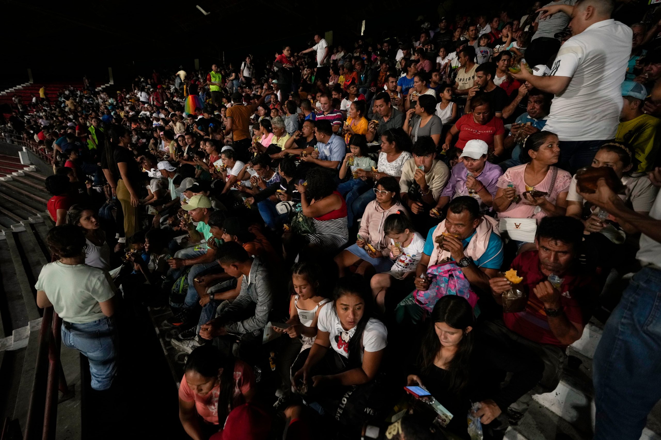 Personas desplazadas por la violencia en localidades de la región del Catatumbo, donde rebeldes del Ejército de Liberación Nacional (ELN) se han enfrentado con exmiembros de las extintas Fuerzas Armadas Revolucionarias de Colombia, se refugian en un estadio de fútbol en Cúcuta, Colombia, el domingo 19 de enero de 2025. (Foto AP/Fernando Vergara)