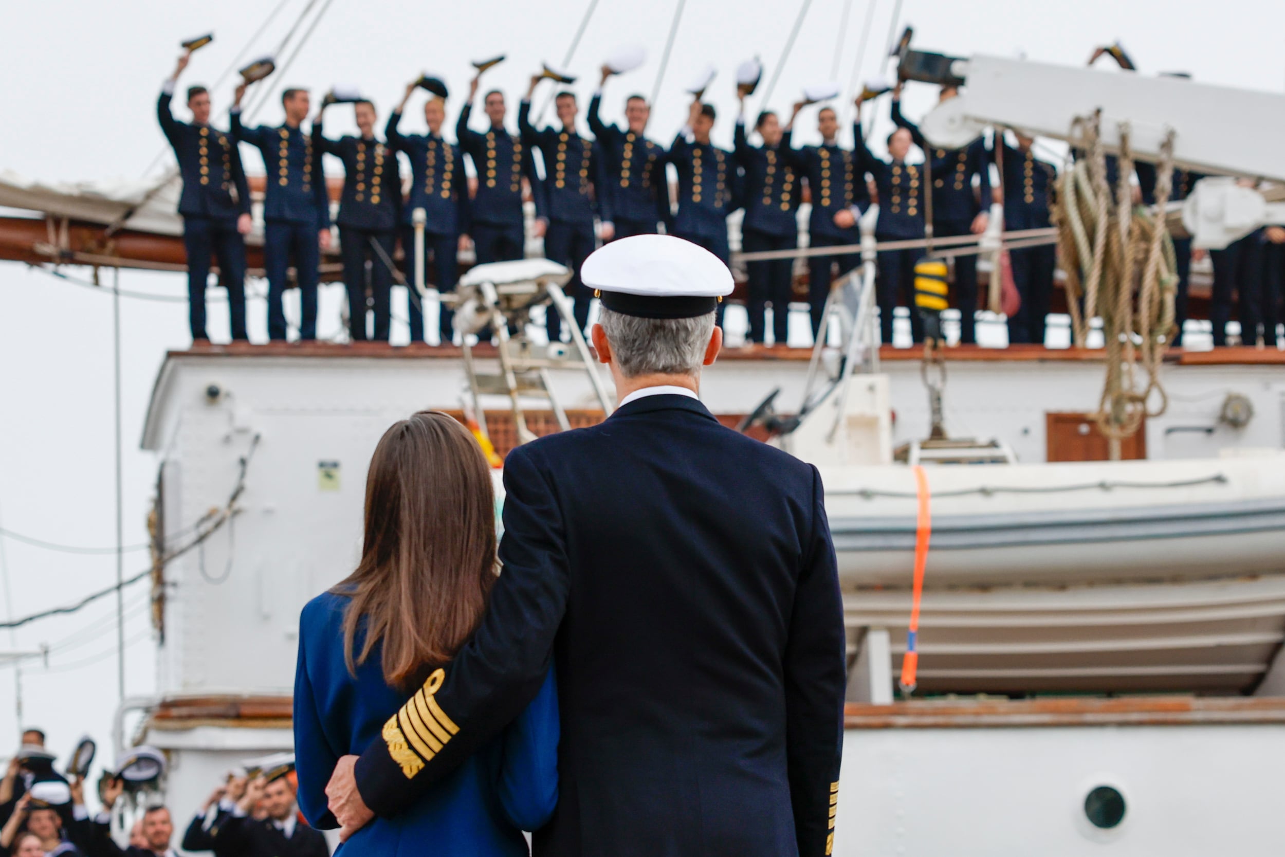 Los setenta y cinco guardiamarinas se despiden de sus familias. En el muelle, el Rey contiene a la Reina tomándola de la cintura.