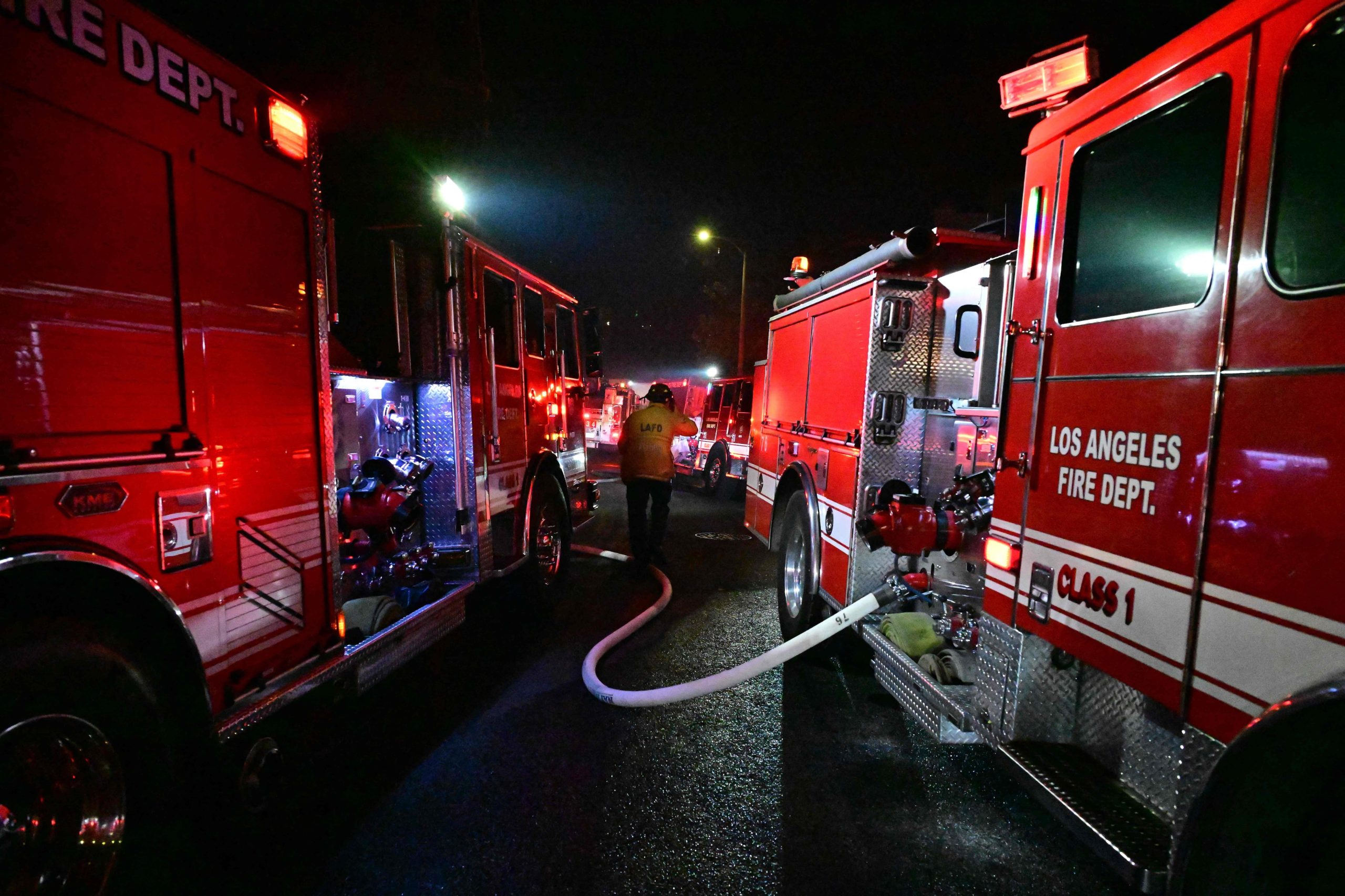 Varios camiones de bomberos en una estrecha calle residencial mientras el Sunset Fire arde cerca de Hollywood Blvd en Hollywood Hills en Los Ángeles, California, el 8 de enero de 2025. 