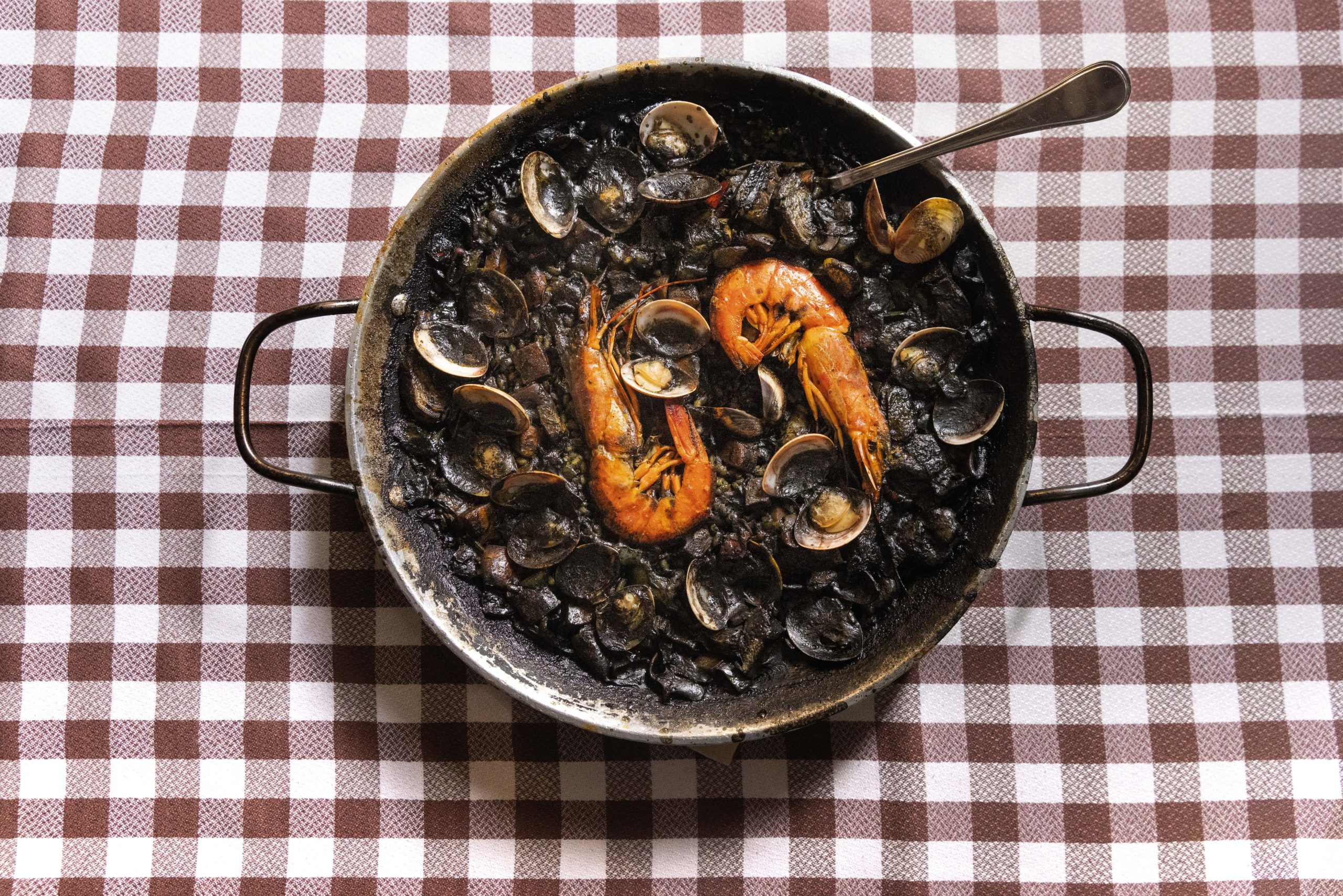 El Glop propone cocina catalana tradicional con un twist. Arroz negro, el clásico del lugar, con sepias, almejas y alcachofas.