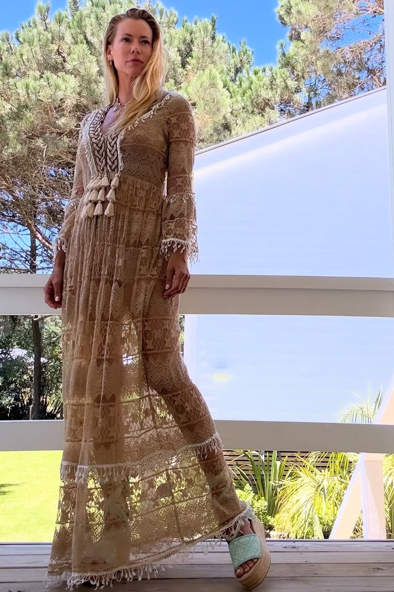 En un modelo after beach, con un vestido de encaje de algodón con galones de pasamanería y borlas. Completó con unas sandalias con plataforma de yute. 