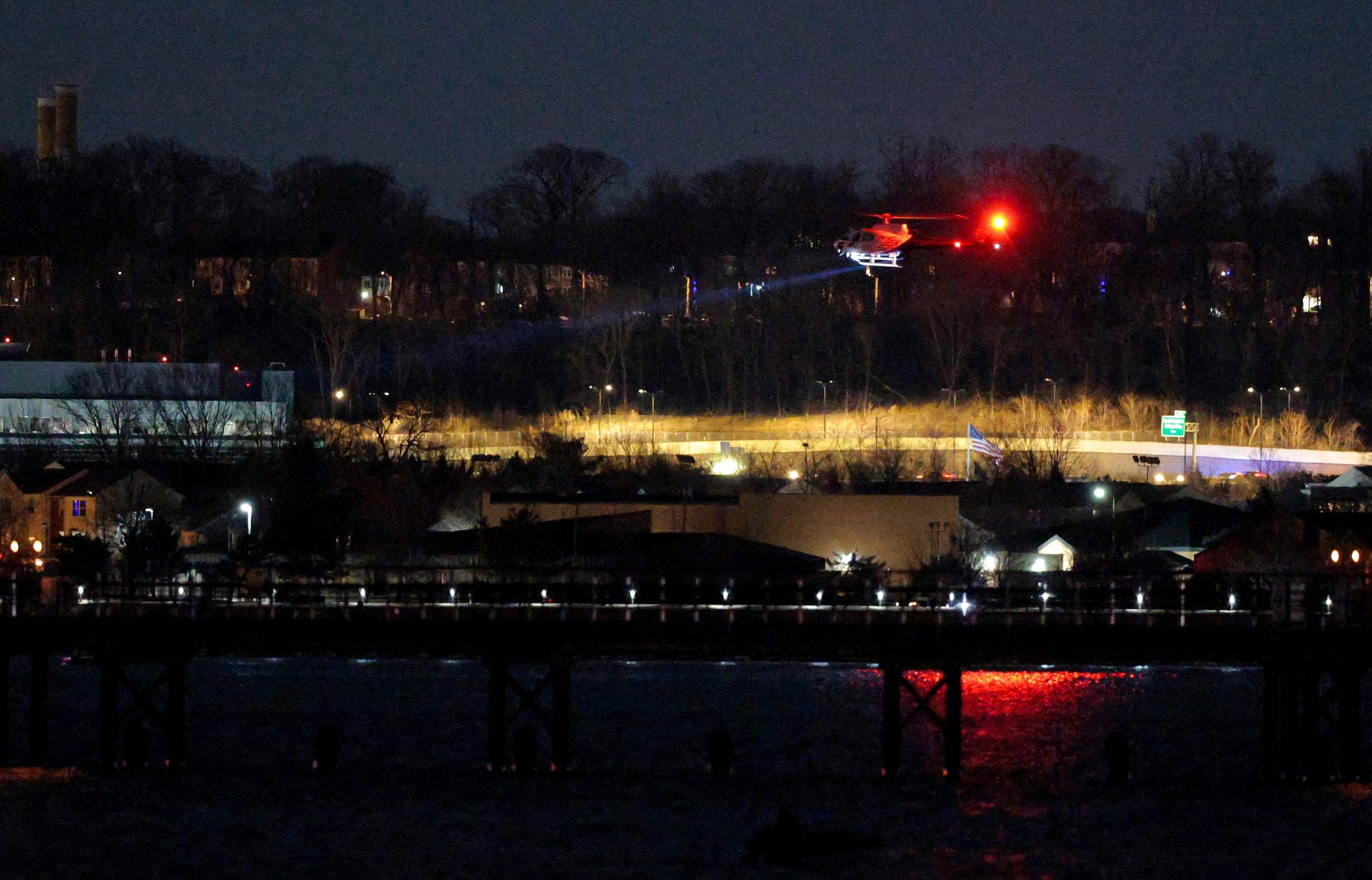 ARLINGTON, VIRGINIA - 30 DE ENERO: Un helicóptero ayuda con las operaciones de búsqueda y rescate sobre el río Potomac cerca del aeropuerto Ronald Reagan