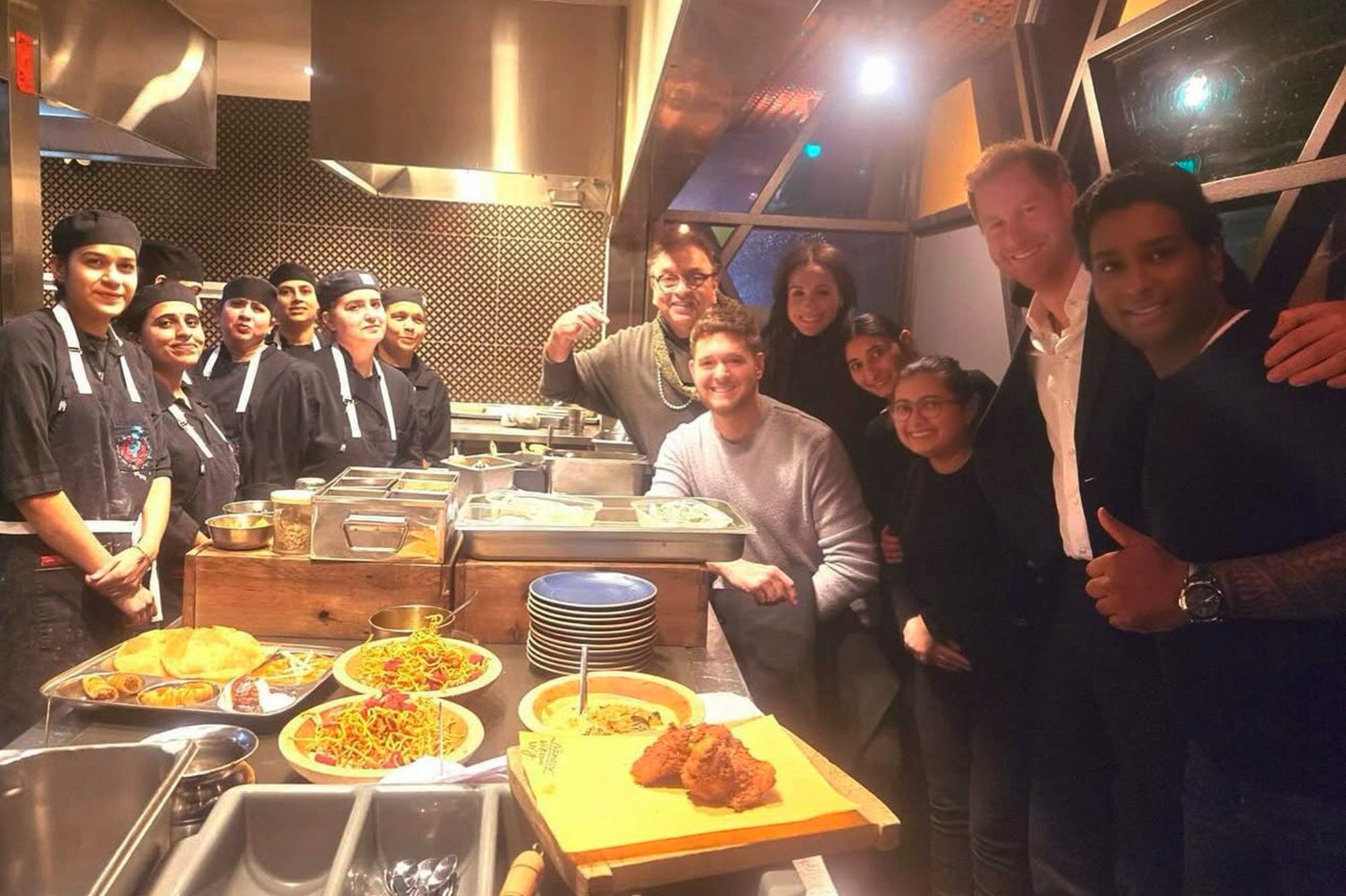 Harry, Meghan y Bublé con los empleados del restaurente Vij's, especializado en comida india, en Vancouver. 