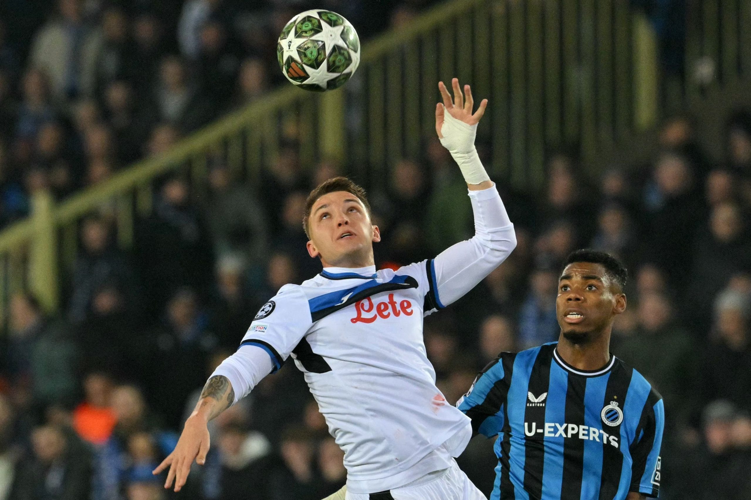 Atalanta's Italian forward #32 Mateo Retegui (L) fights for the ball with Club Brugge's Nigerian midfielder #15 Raphael Onyedika Nwadike during the UEFA Champions League knockout phase play-off 1st leg football match between Club Brugge KV and Atalanta at the Jan-Breydel stadium in Sint-Andries, Bruges, on February 12, 2025. (Photo by NICOLAS TUCAT / AFP)