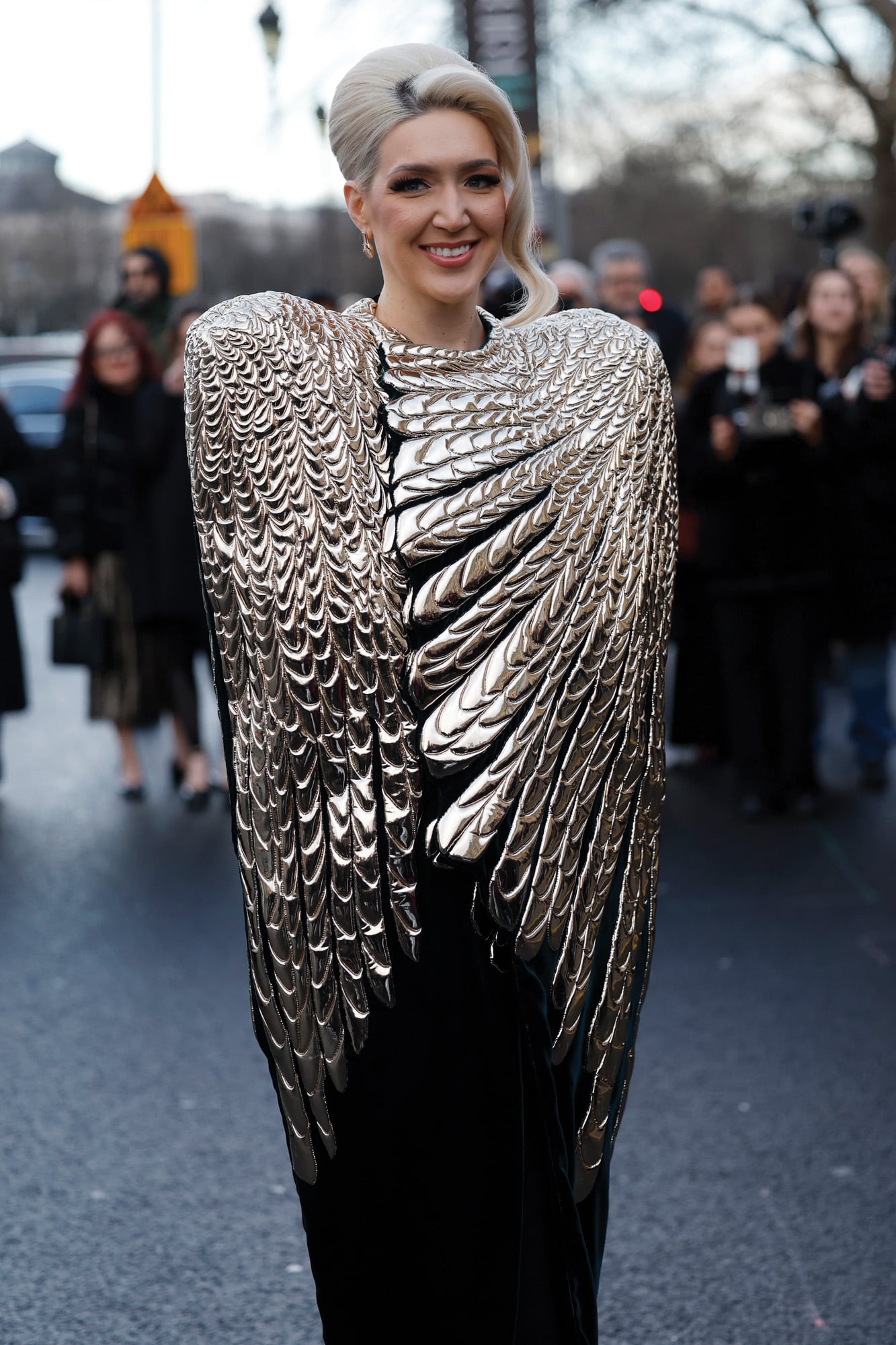 La capa con forma de plumas de una de las invitadas causó sensación a la entrada del desfile de Schiaparelli.