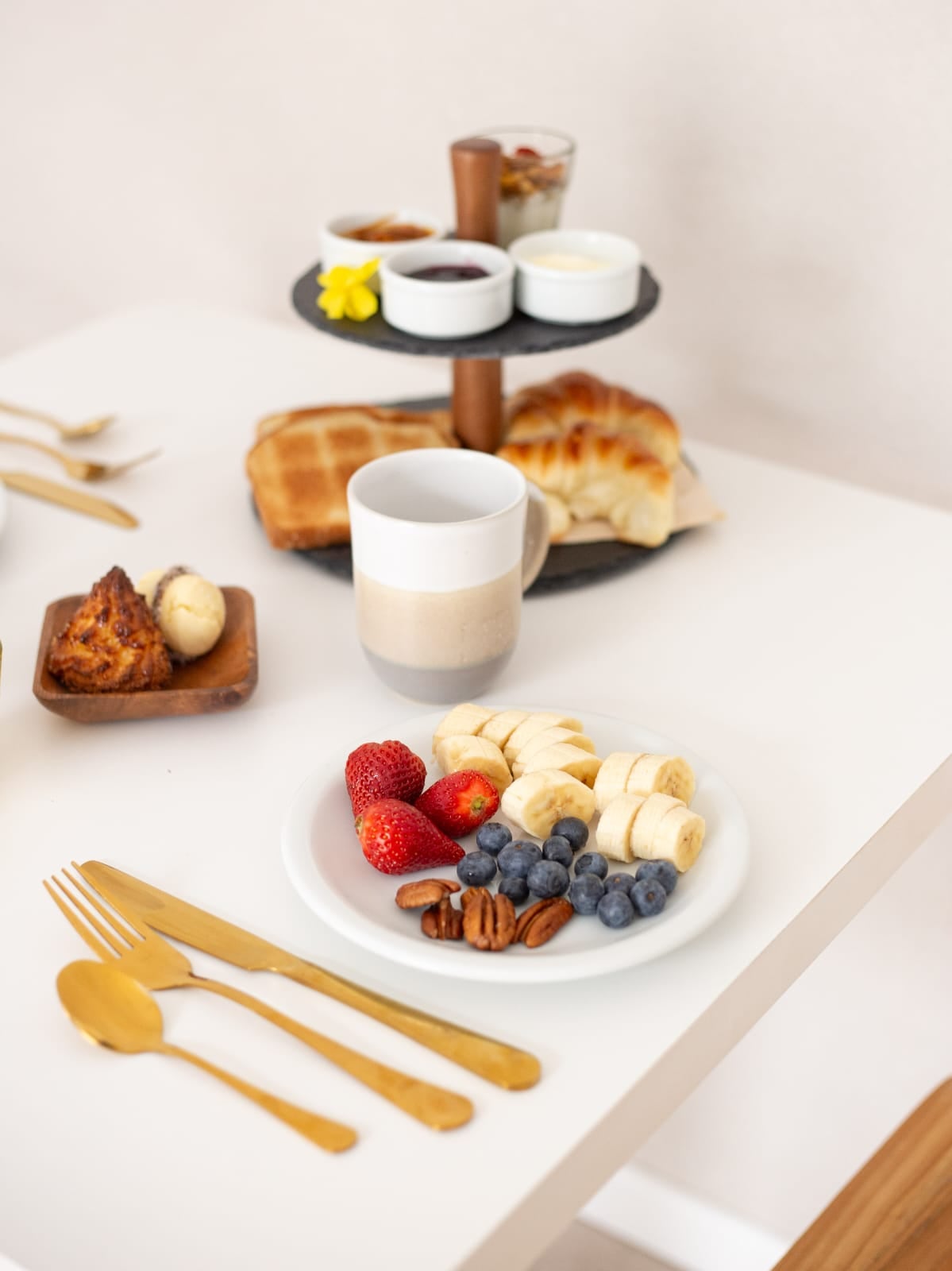 El desayuno se sirve en vajilla de diseño, con medialunas, pan casero con quesos y mermeladas, cuadraditos dulces, granola, yogur, entre otras opciones que van variando.