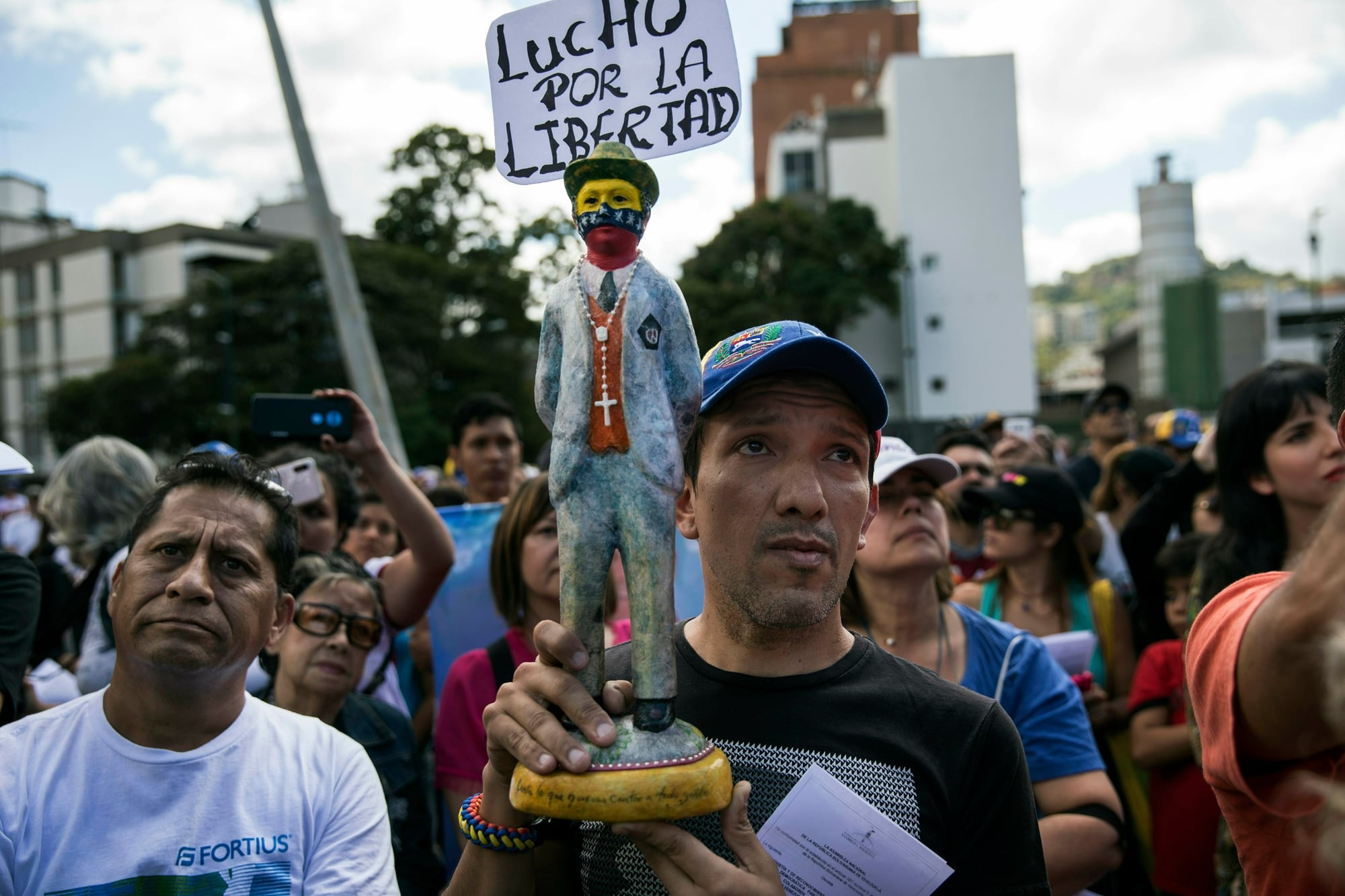 Un hombre sostiene una estatuilla del santo venezolano