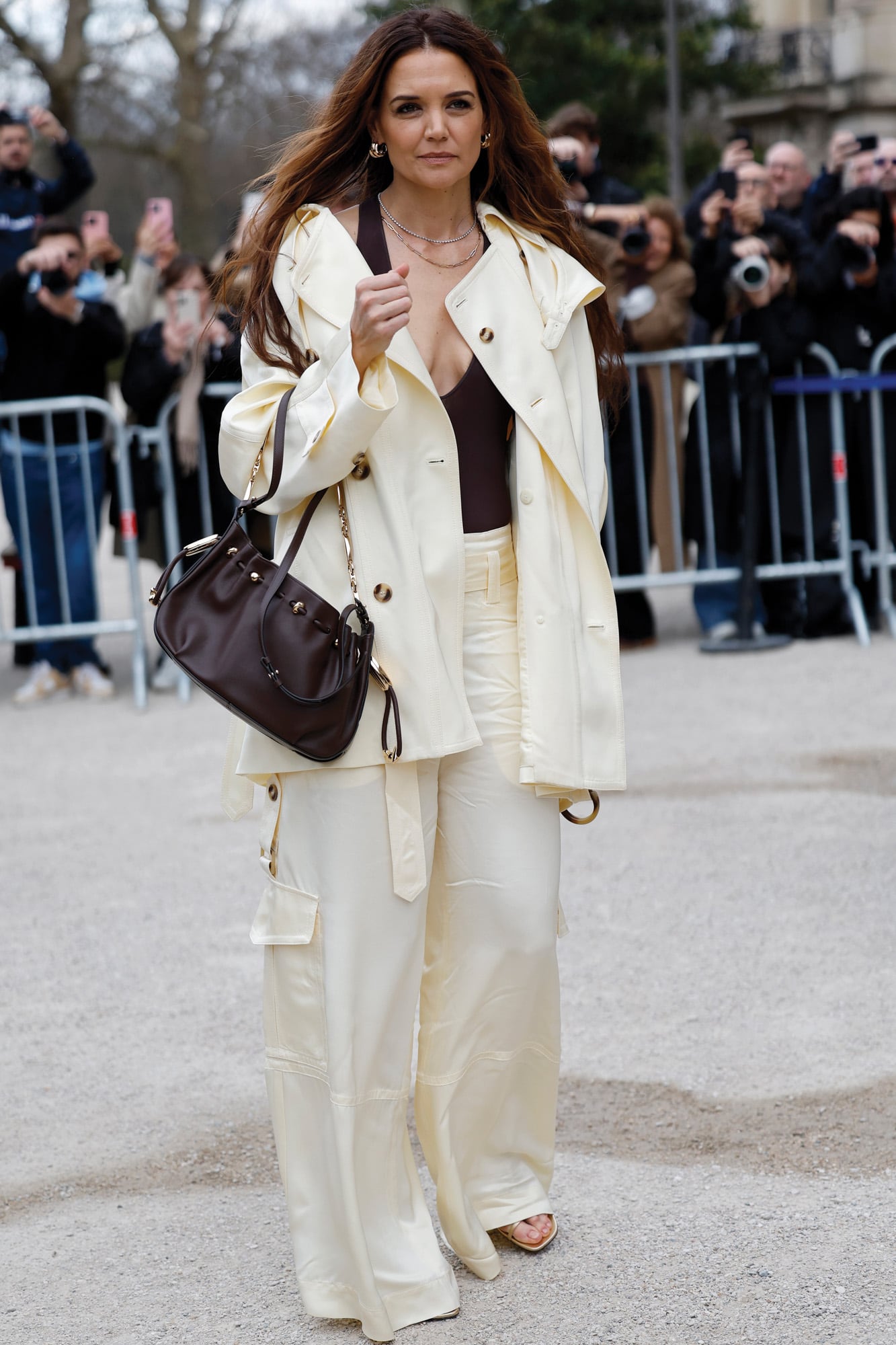 Katie Holmes asistió al desfile de Zimmermann con un conjunto de esa marca: chaqueta y pantalones cargo en color manteca sobre un escotado body negro, y cartera marrón. 