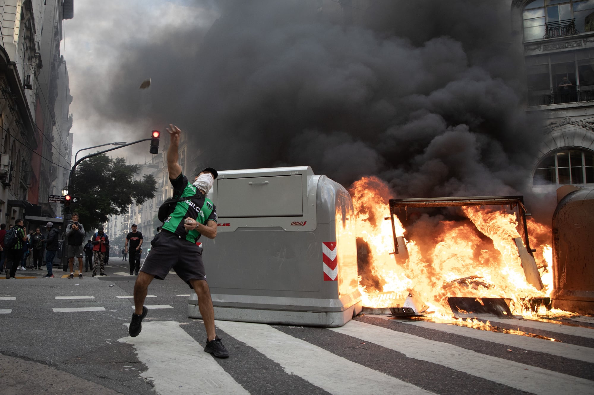 Un hombre lanza una piedra durante una protesta de jubilados respaldados por aficionados del fútbol, en las inmediaciones del Congreso Nacional el 12 de marzo de 2025. Incidentes se produjeron este miércoles en inmediaciones del Congreso de Argentina, donde aficionados al fútbol se movilizaron para respaldar a jubilados que realizan habitualmente una marcha en reclamo de la mejora de sus haberes.