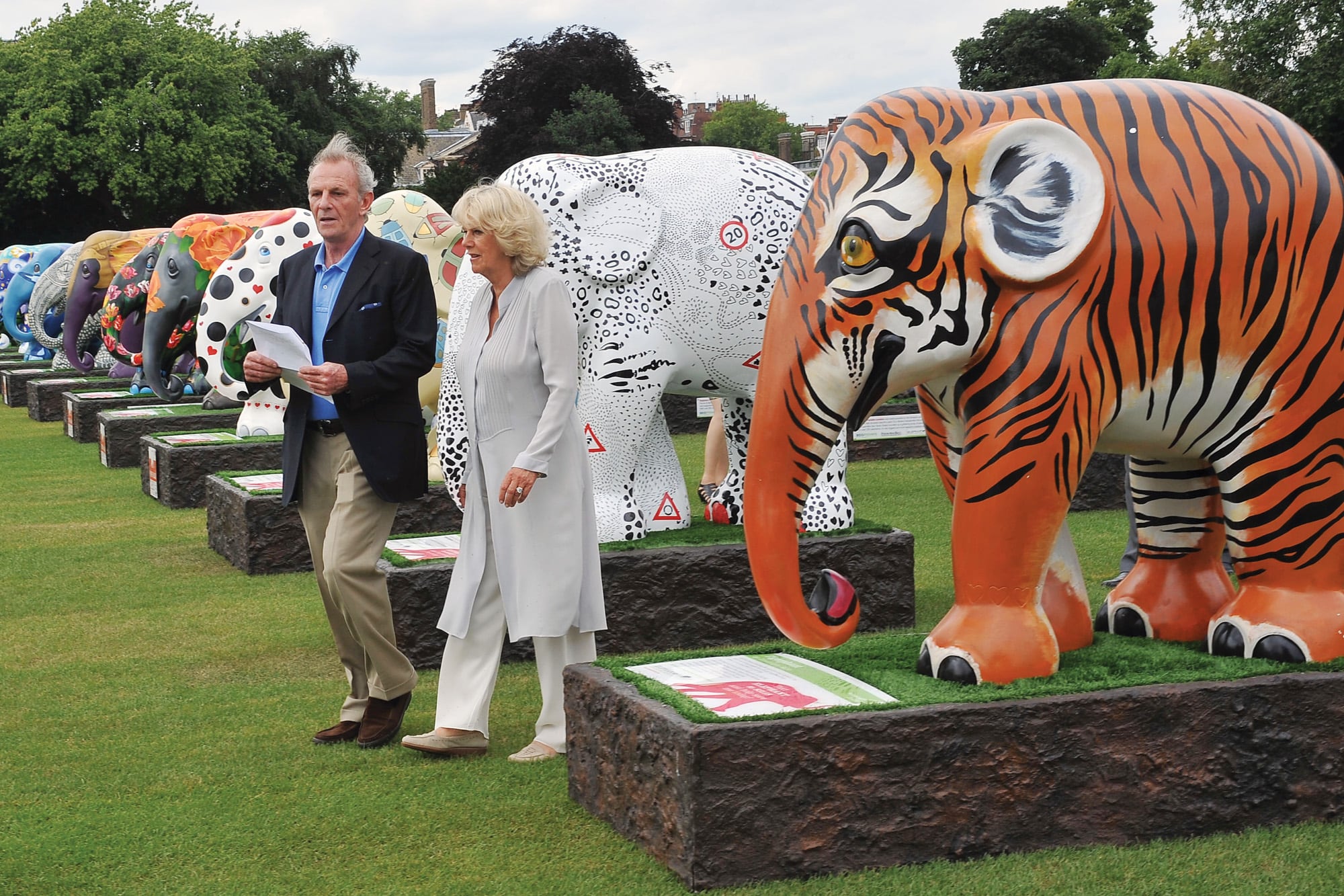 Camilla y su hermano menor, Mark, recorren la exhibición “El desfile del elefante”, organizada en 2010 en los jardines del Hospital Chelsea. La iniciativa incluyó esculturas de elefantes realizadas por distintos artistas.