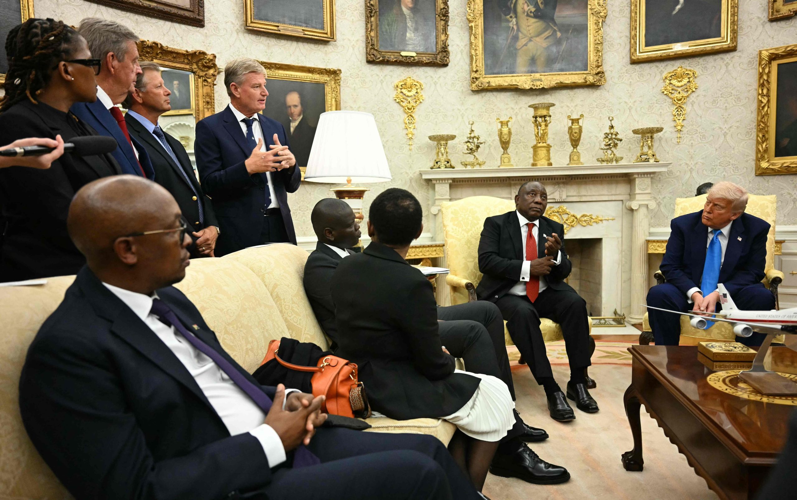 El presidente estadounidense Donald Trump y el presidente sudafricano Cyril Ramaphosa escuchan a un miembro de la delegación sudafricana durante una reunión en la Oficina Oval 