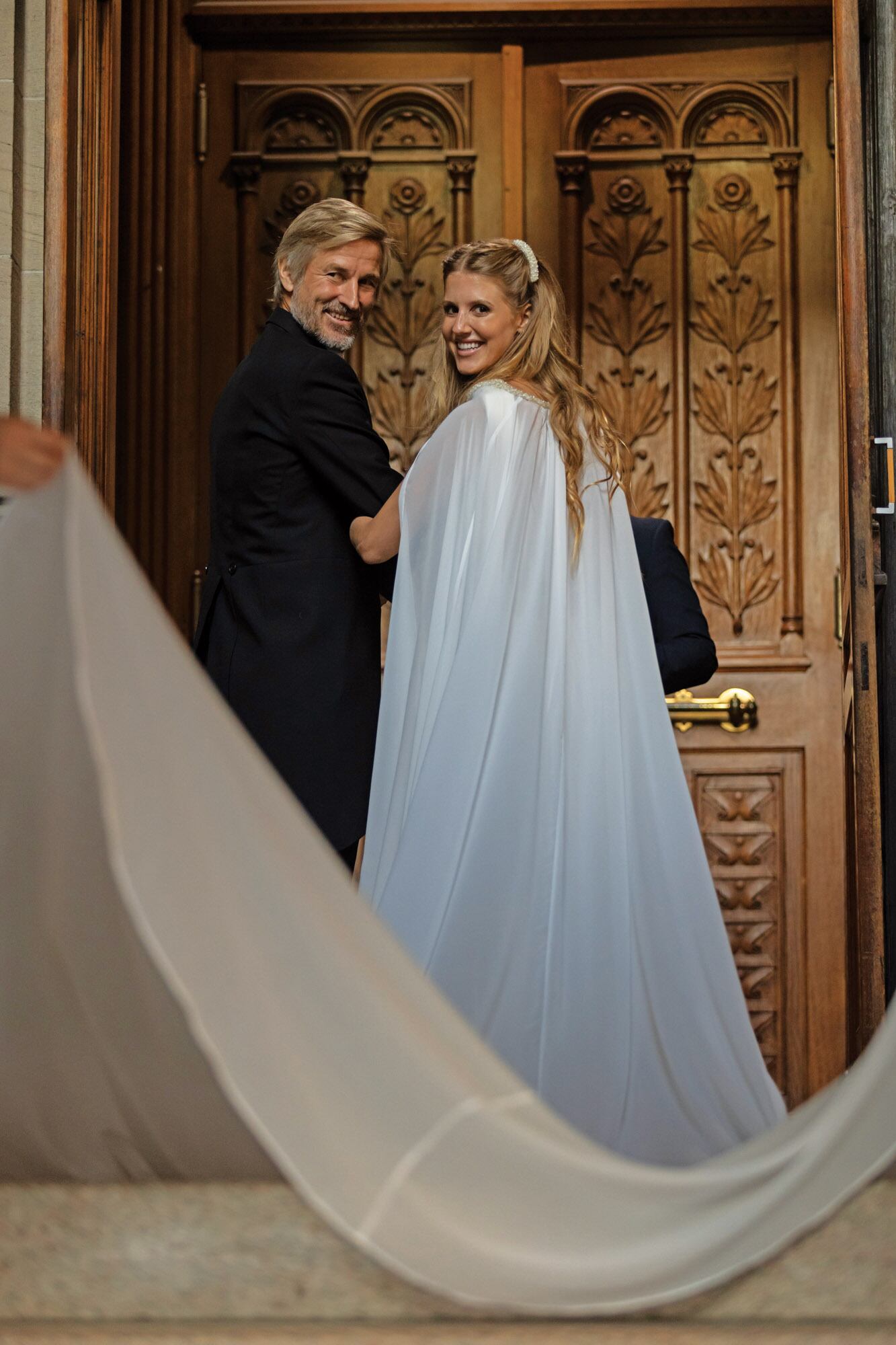Tati lució un vestido de Evangelina Bomparola, de estilo grecorromano, realizado en crêpe georgette de seda natural; los hombros y la cintura estaban bordados a mano con cristales. Realizada en gasa de seda natural, la cola estaba sostenida en los hombros con el mismo bordado. 