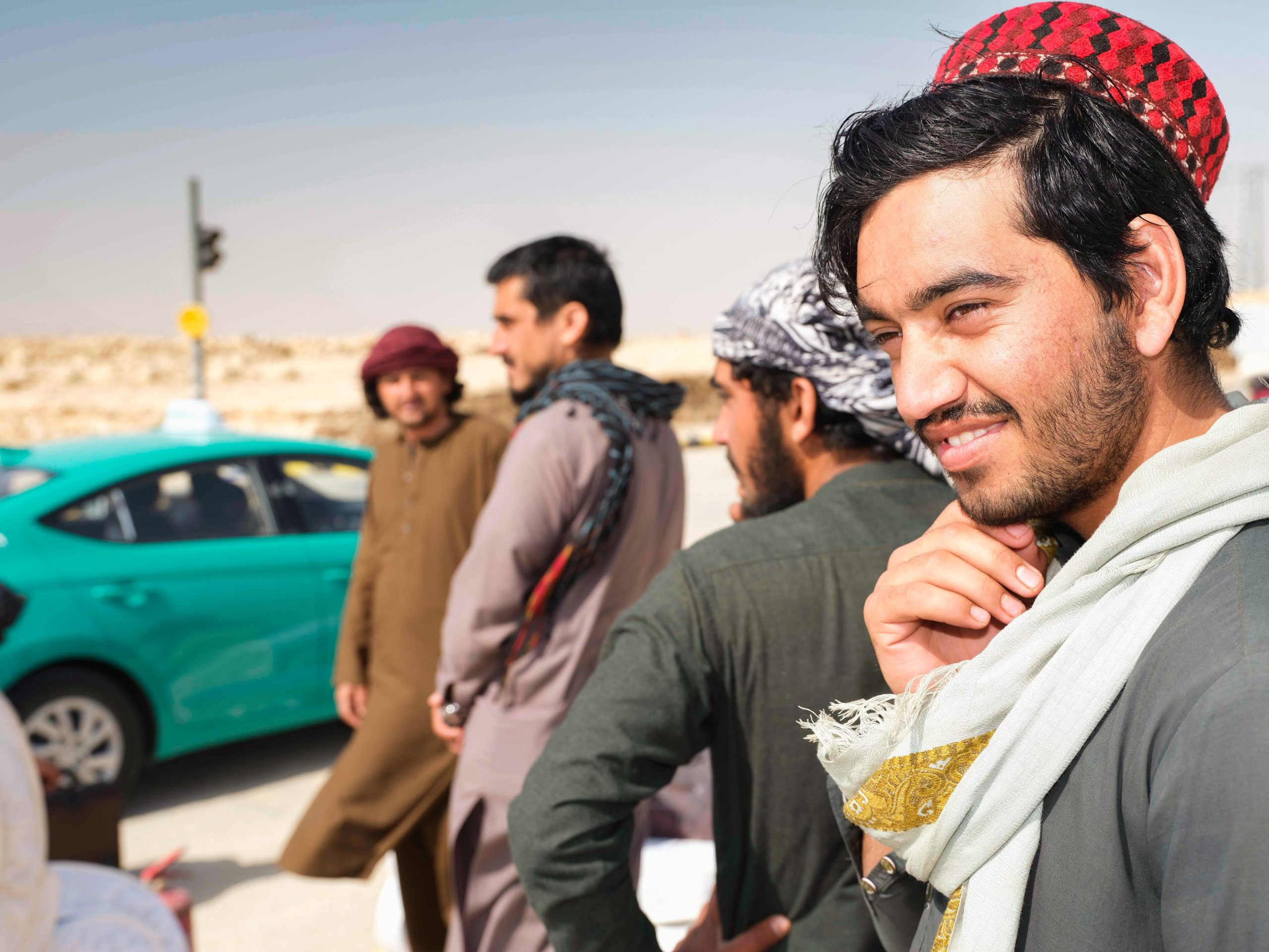 Trabajadores de la construcción afganos esperan un Uber que los traslade hacia su casa, en las afueras de Riyadh.