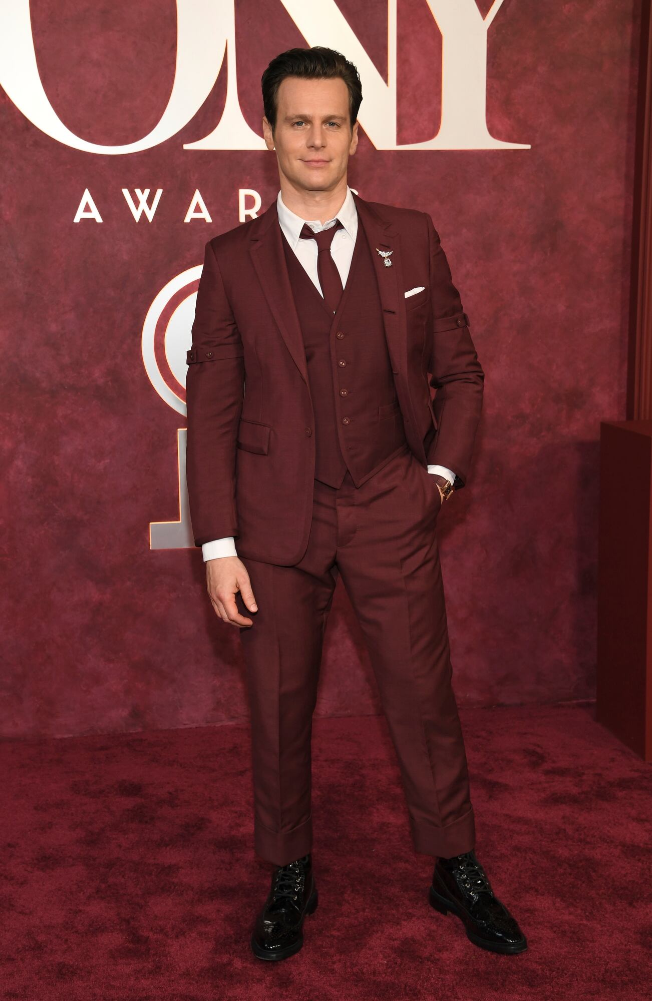 Jonathan Groff a tono con la alfombra con un traje de tres piezas en color bordo. El actor compite por su rol en Just in Time