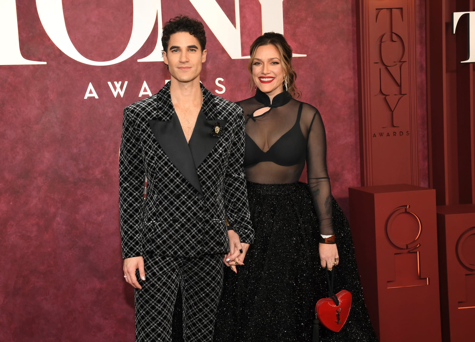 Otra de las parejas más esperadas en la noche de los Tony fue la de Darren Criss y Mia Swier. Mientras que la ex estrella de Glee -que obtuvo su primera nominación al premio Tony por su actuación principal en Maybe Happy Ending- sorprendió con un traje con estampa geométrica, su mujer deslumbró con un top transparente y una falda voluminosa con brillos. Su mini cartera en forma de corazón a juego con su labial se llevó todas las miradas
