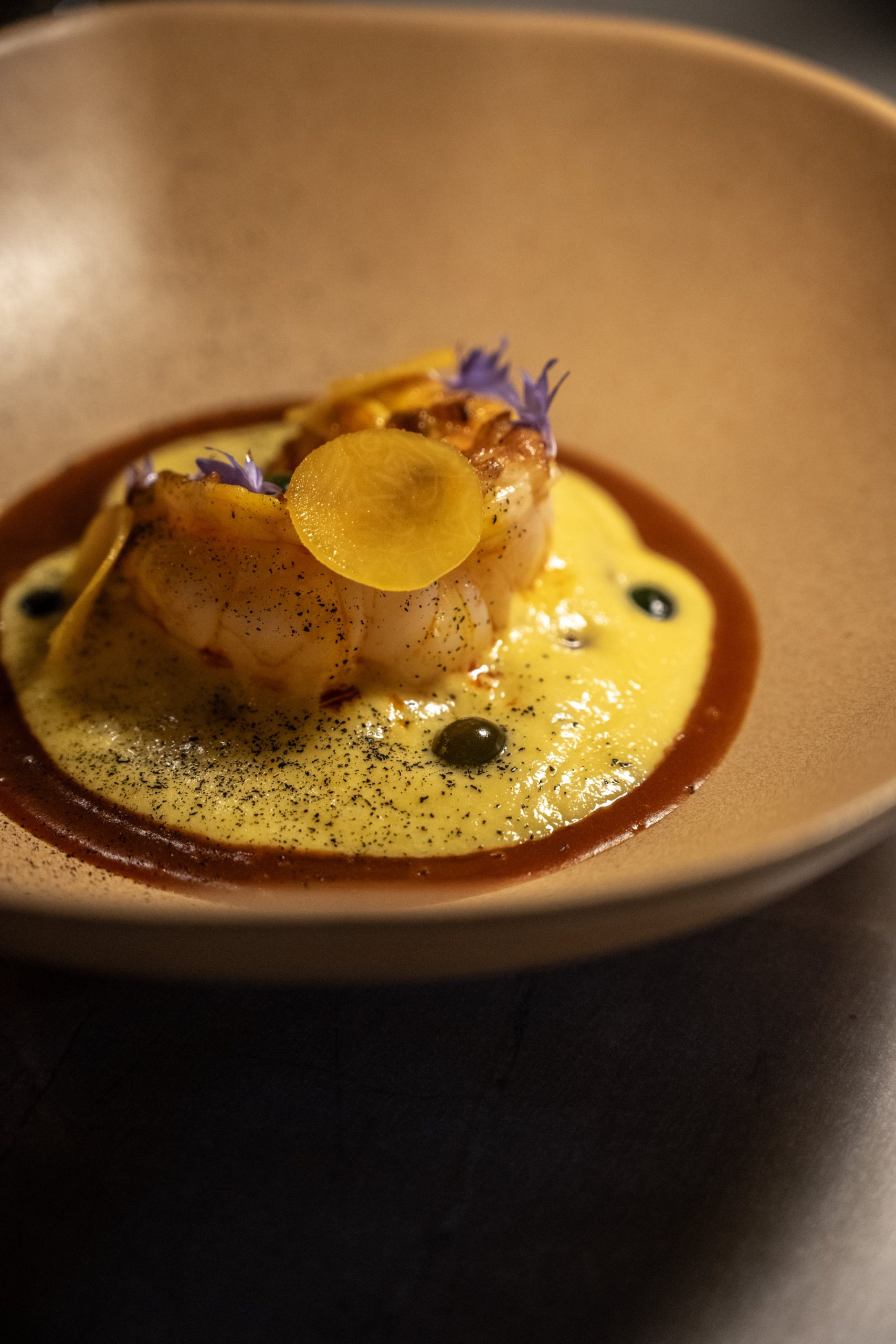 Langostino a la plancha sobre espuma de ají amarillo en Contraste.