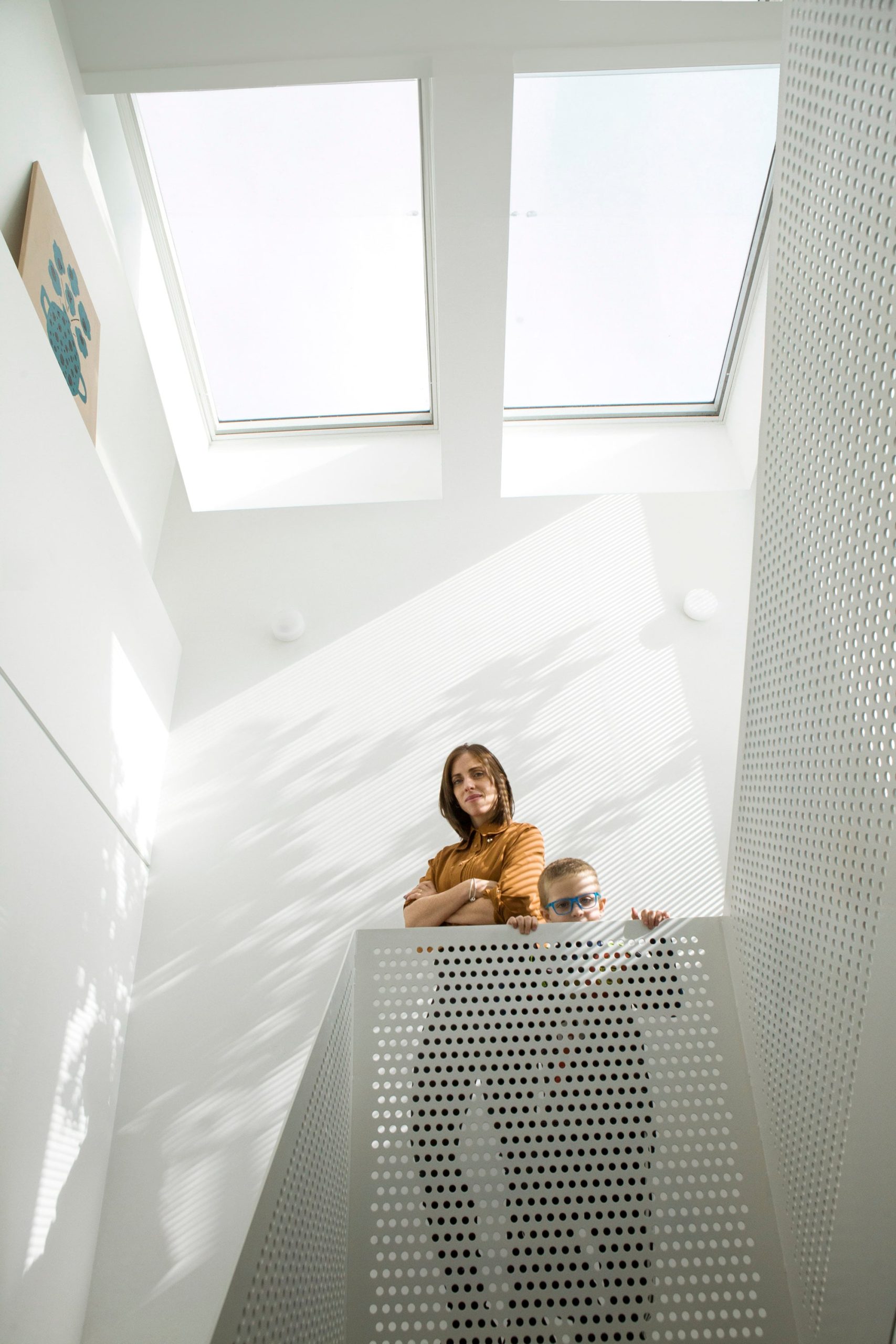 Cielo Pipkin con uno de sus tres hijos, al tope de la escalera que lleva a los espacios de trabajo de ella y su marido que construyeron sobre la losa del último piso.