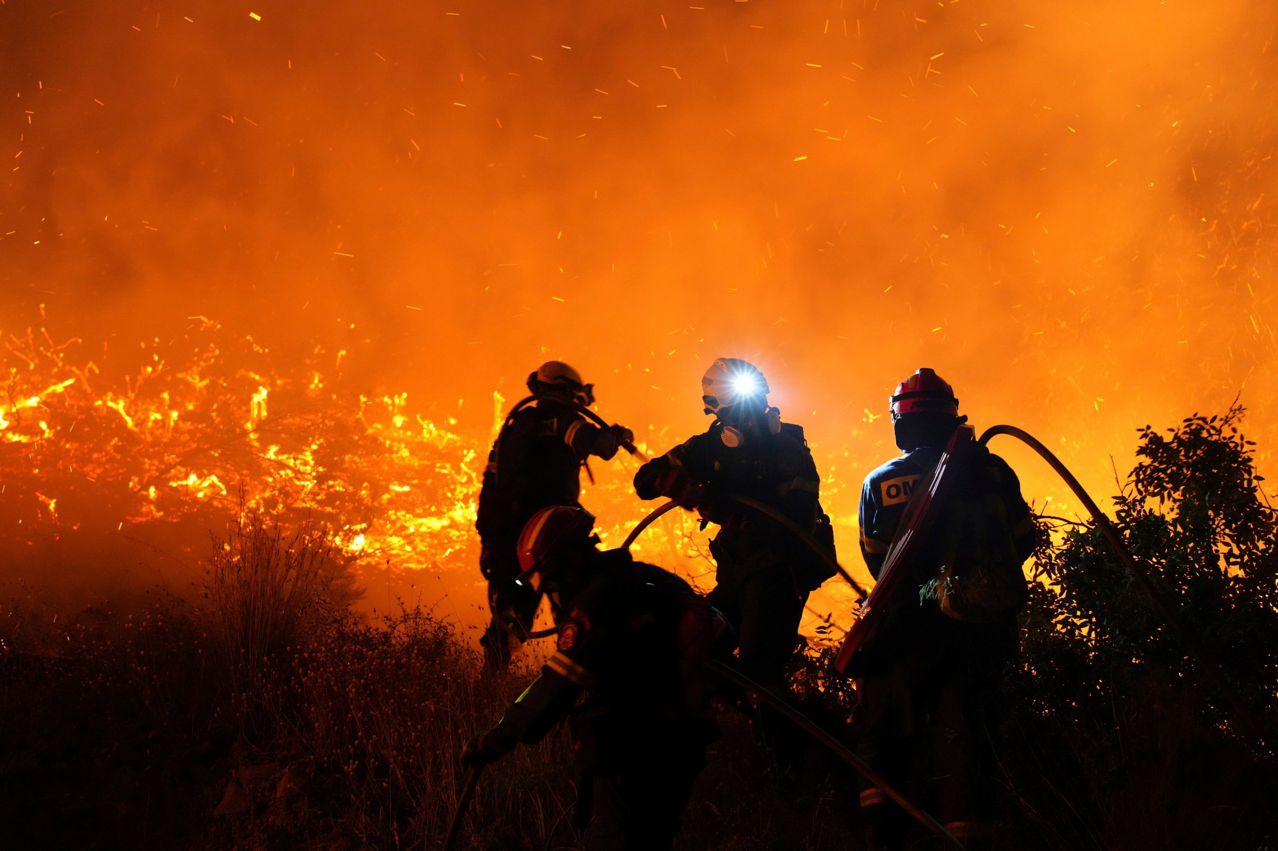 Bomberos luchan contra un gran incendio forestal en Kofinas, en la isla de Chios, en el Egeo oriental, en Grecia, la noche del domingo 22 de junio de 2205. (Pantelis Fykaris/Politischios.gr via AP)