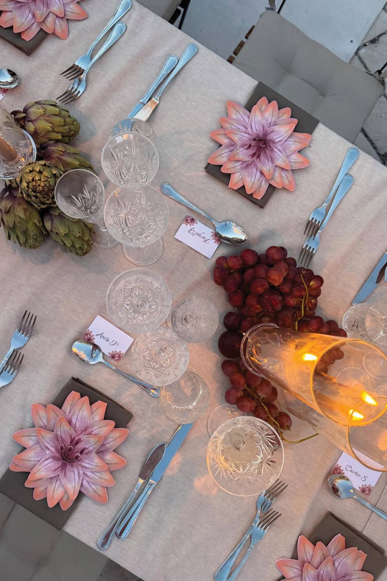 Detalle de la mesa decorada con velas, flores, uvas y verduras. 