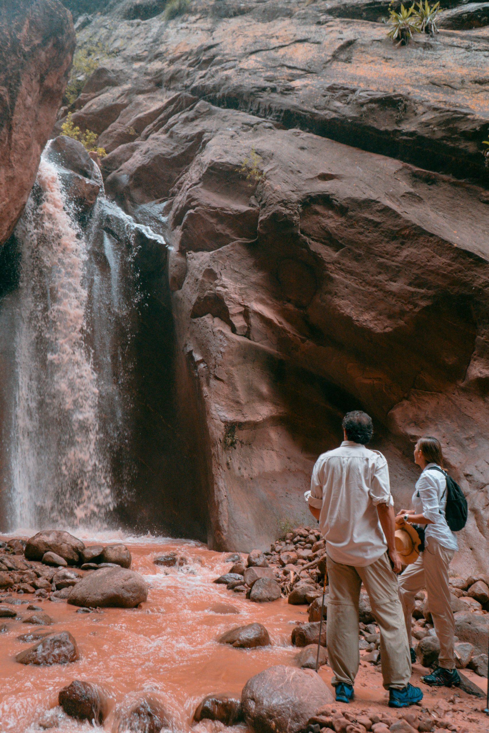 Safari a la Cascada del Río Tipal, caminando el último tramo de la experiencia por el lecho del río, entre paredones de roca rojiza, y llegamos a esta cascada de 12 m. de altura.