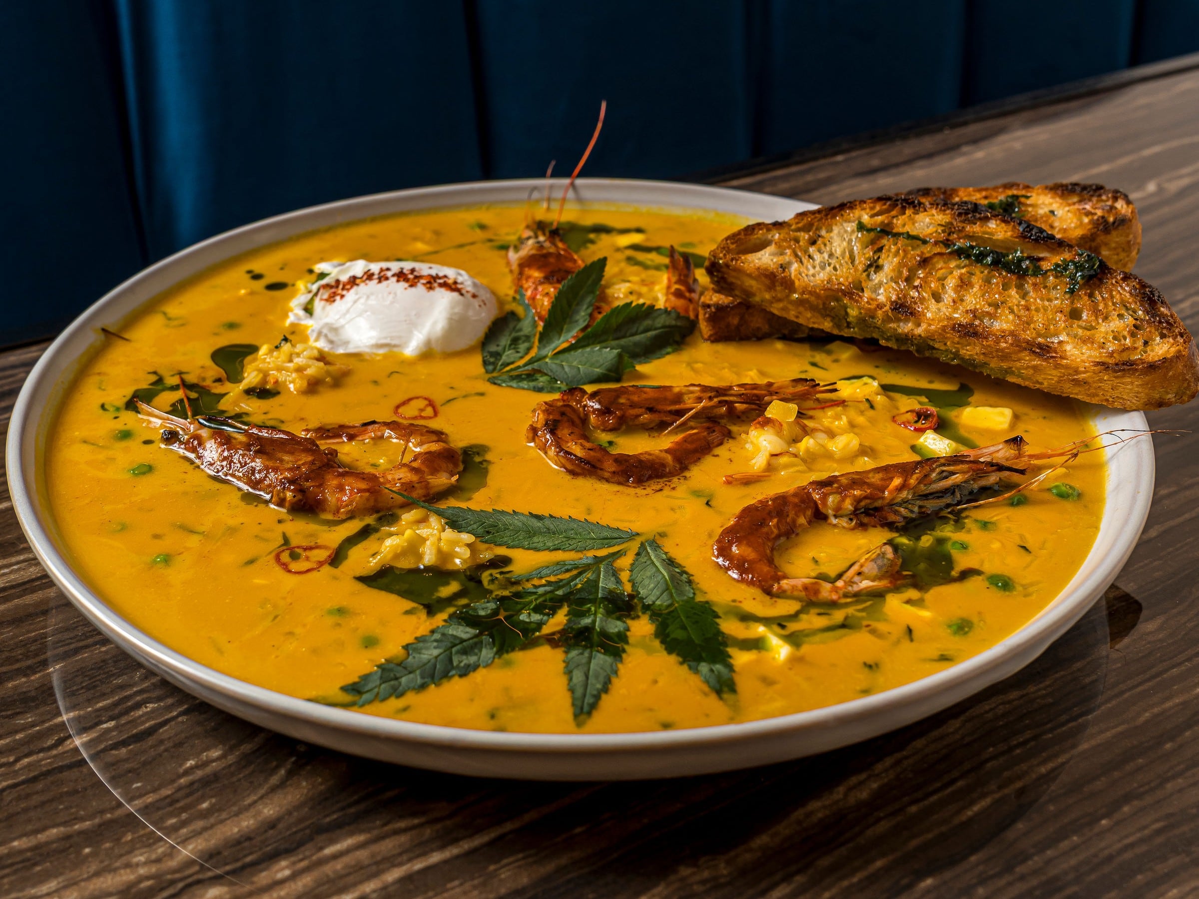 Chupe de langostinos en Grau Cebichería: ají amarillo, arroz, huacatay y langostino bañado en salsa anticuchera. Sale con un huevito poché