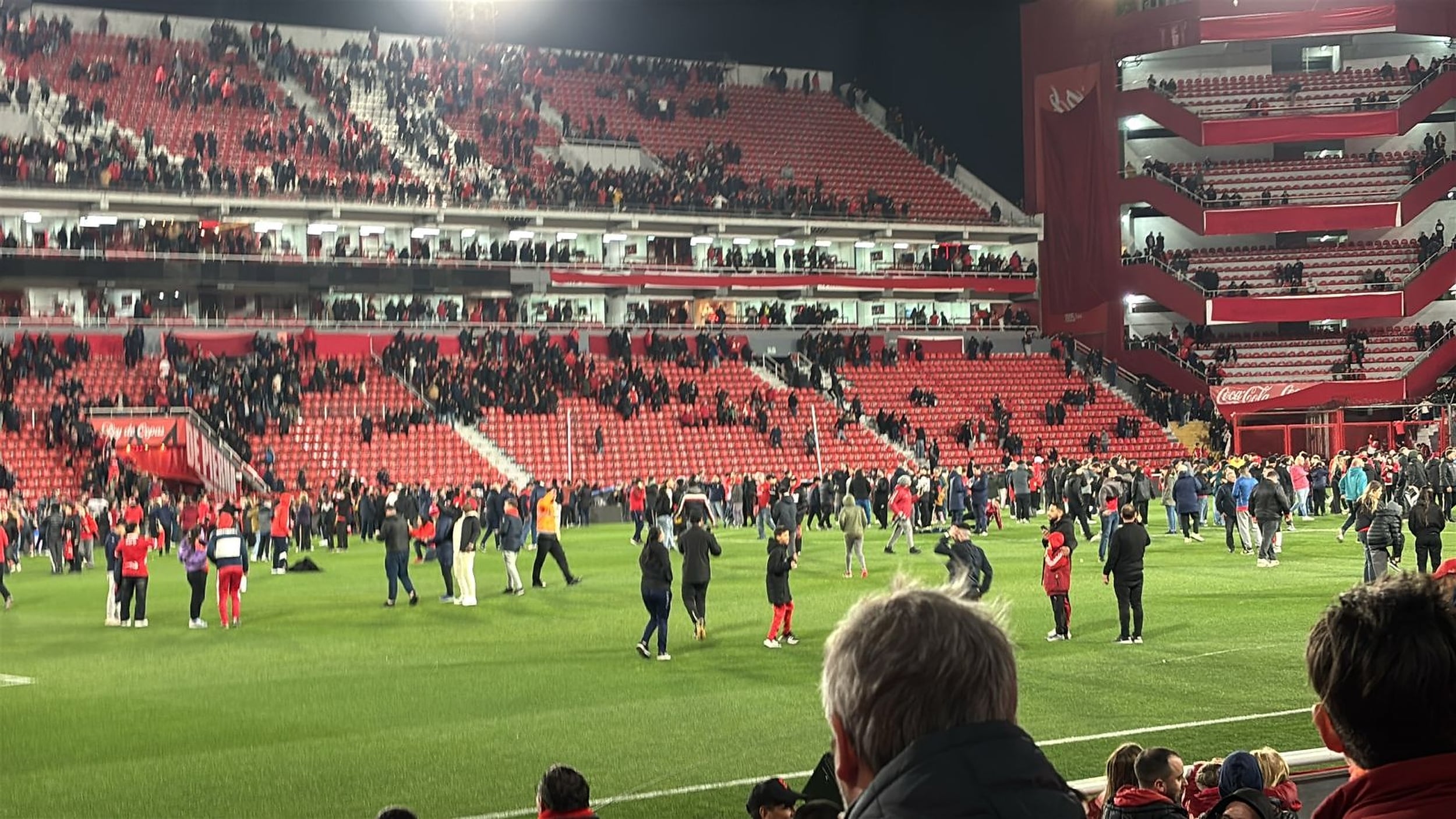 Una buena parte del grupo de hinchas que estaban en las tribunas optó por meterse al campo de juego para protegerse tras la suspensión de Independiente 1 vs. Universidad de Chile 1, por la Copa Sudamericana.