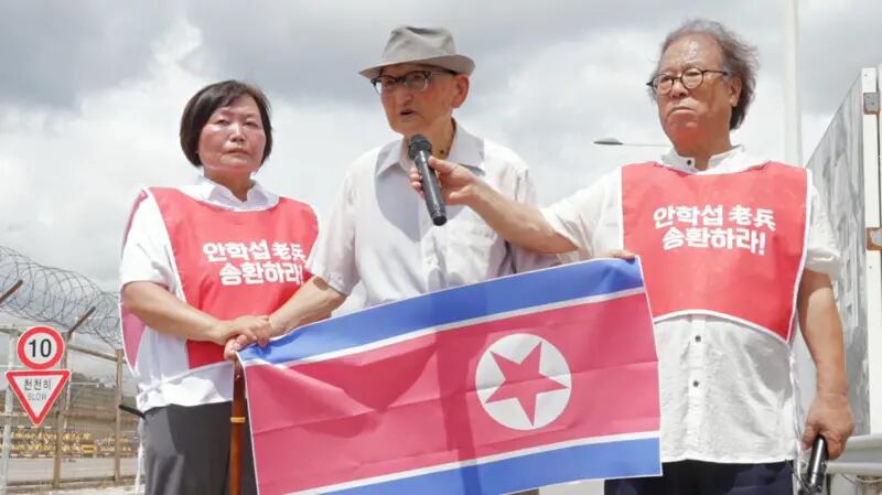 Después de que Ahn Hak-sop fue rechazado en la frontera habló frente a las cámaras sosteniendo una bandera de Corea del Norte