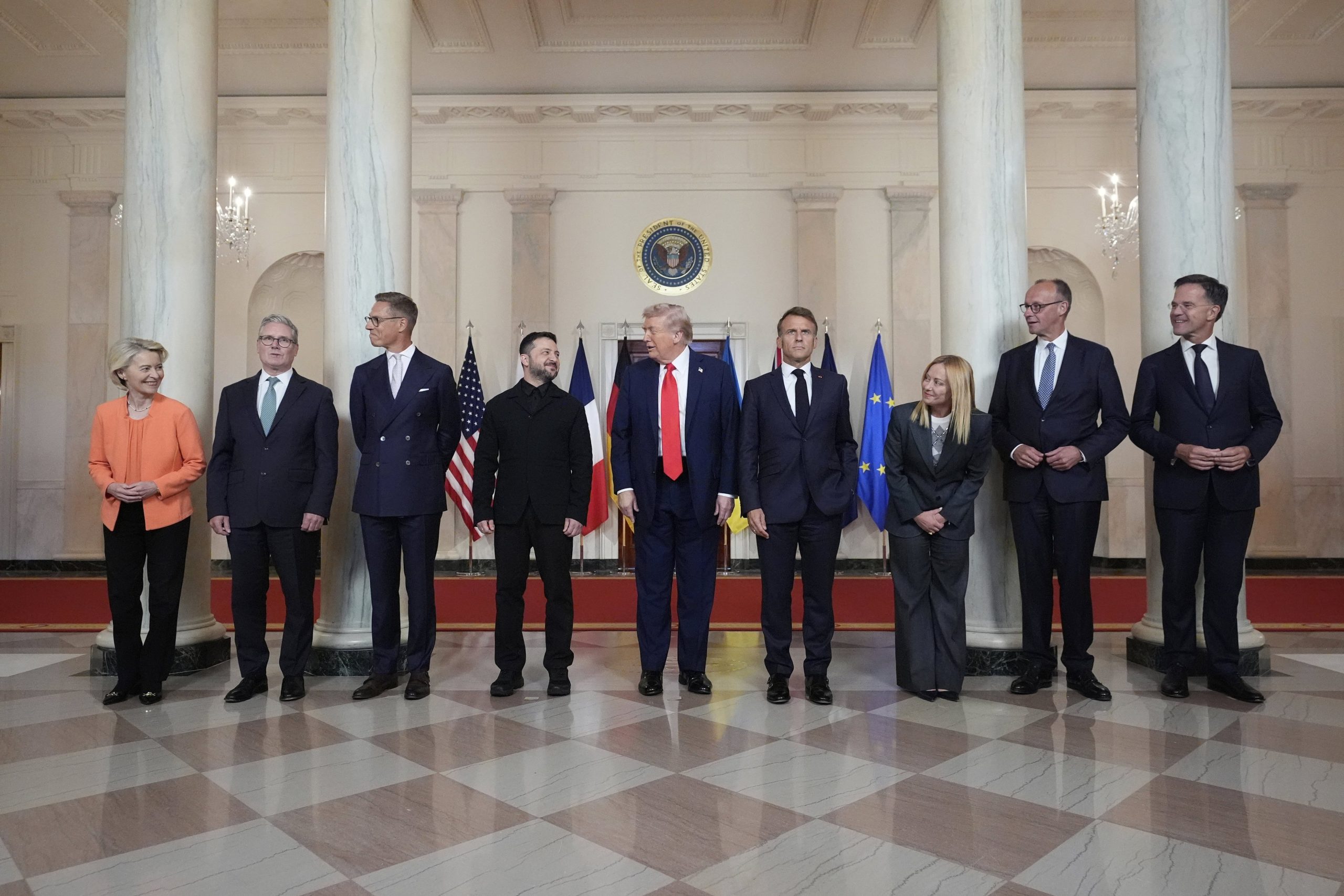 La presidenta de la Comisión Europea, Ursula von der Leyen (de izquierda a derecha), el primer ministro británico, Keir Starmer; el presidente finlandés, Alexander Stubb; el presidente ucraniano, Volodimir Zelensky; el presidente Donald Trump; el presidente francés, Emmanuel Macron; la primera ministra italiana, Giorgia Meloni; el canciller alemán, Friedrich Merz; y el secretario general de la OTAN, Mark Rutte, posan para una foto de grupo en el Gran Vestíbulo de la Casa Blanca, el lunes 18 de agosto de 2025, en Washington.