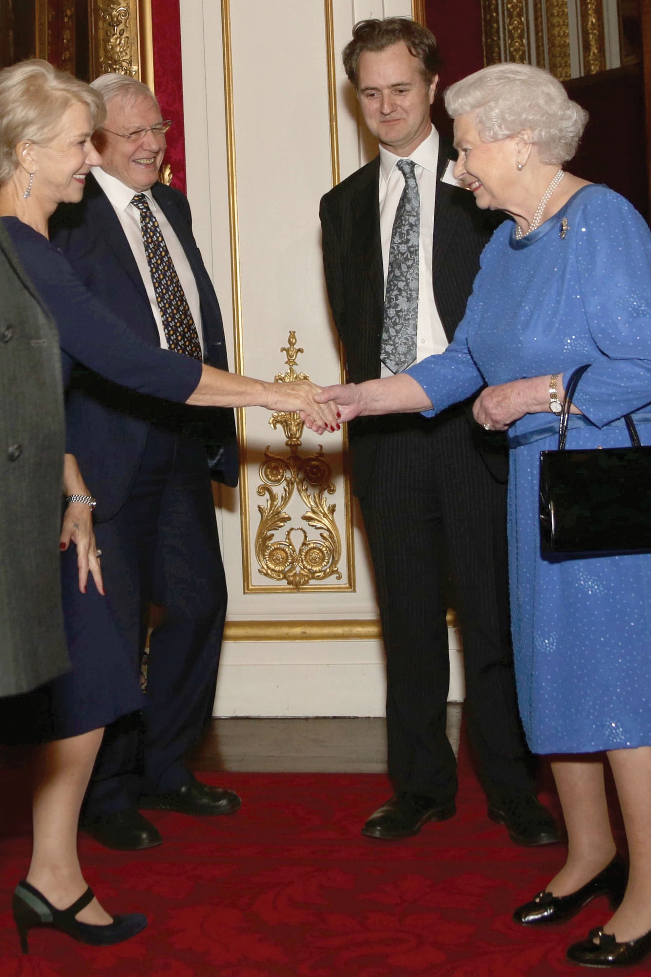 Saludando a la reina Isabel II en un evento en el Palacio de Buckingham, en febrero de 2014