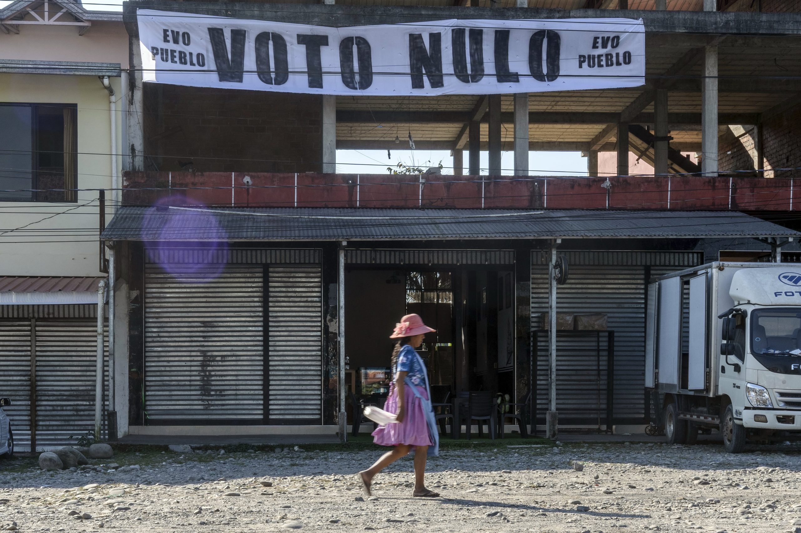 Una mujer pasa frente a un cartel que promueve el voto nulo en las próximas elecciones presidenciales y legislativas, una campaña encabezada por el expresidente Evo Morales, quien tiene prohibido postularse, en Villa Tunari, Bolivia, el viernes 15 de agosto de 2025.