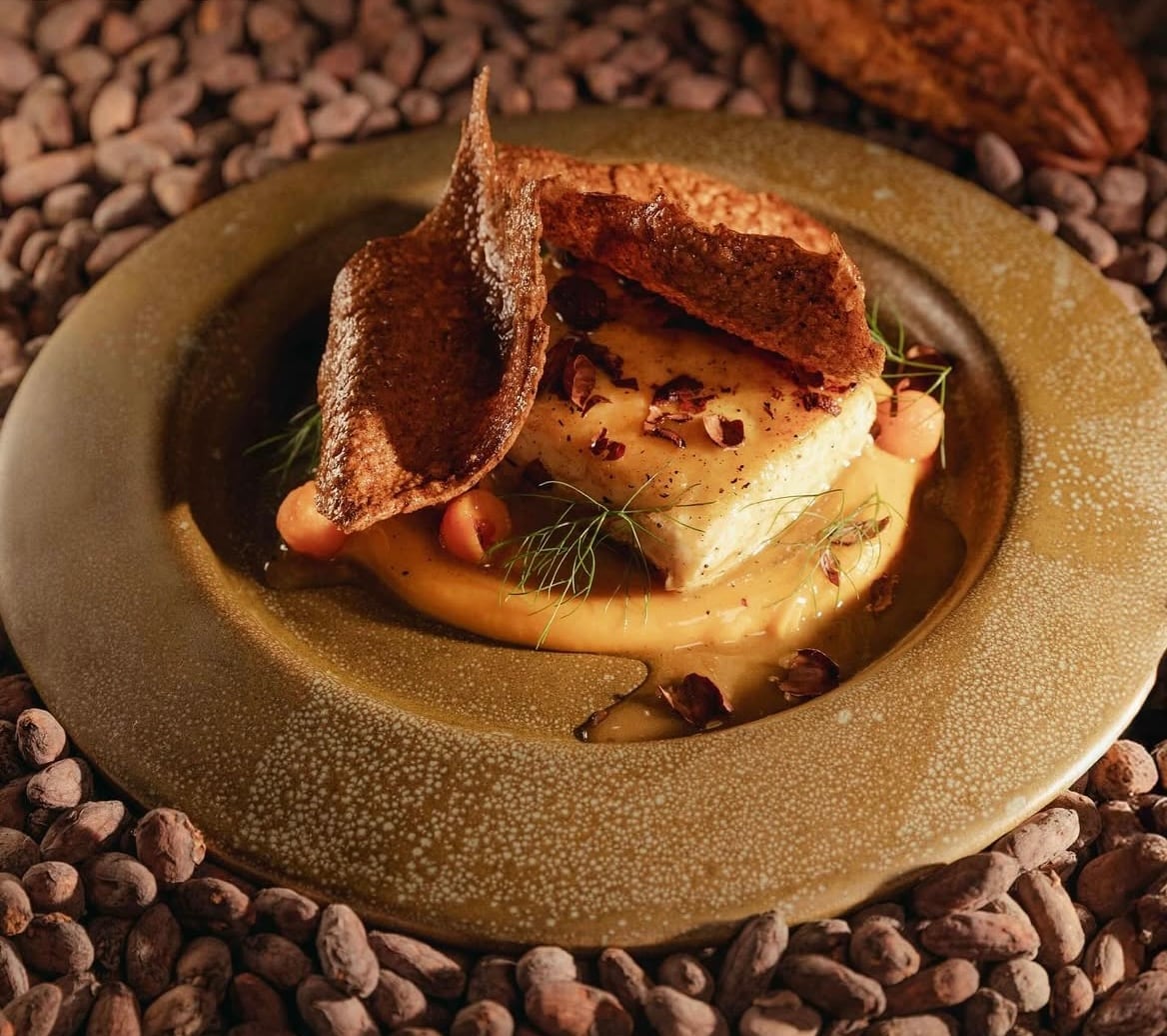 Surubí pochado en gastrique de limón negro, puré de boniato y cascarilla frita.