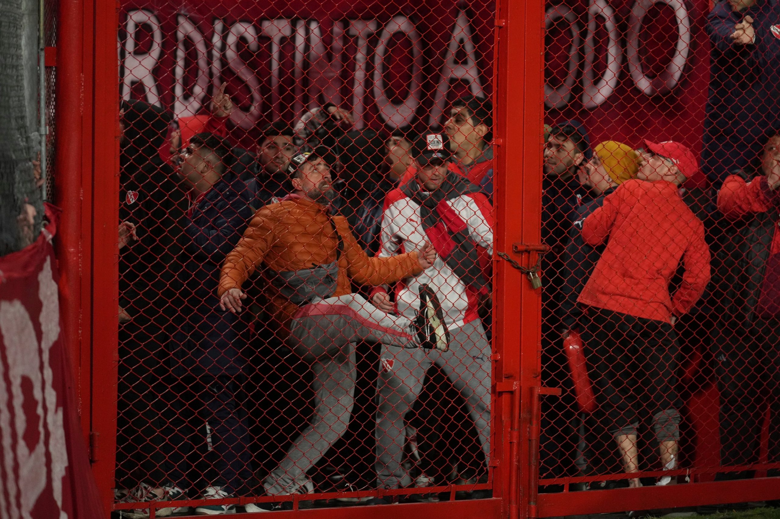 Hinchas de Independiente tratan de abrir una reja por la fuerza durante el partido de la Copa Sudamericana ante Universidad de Chile. (Foto: AP/Gustavo Garello).