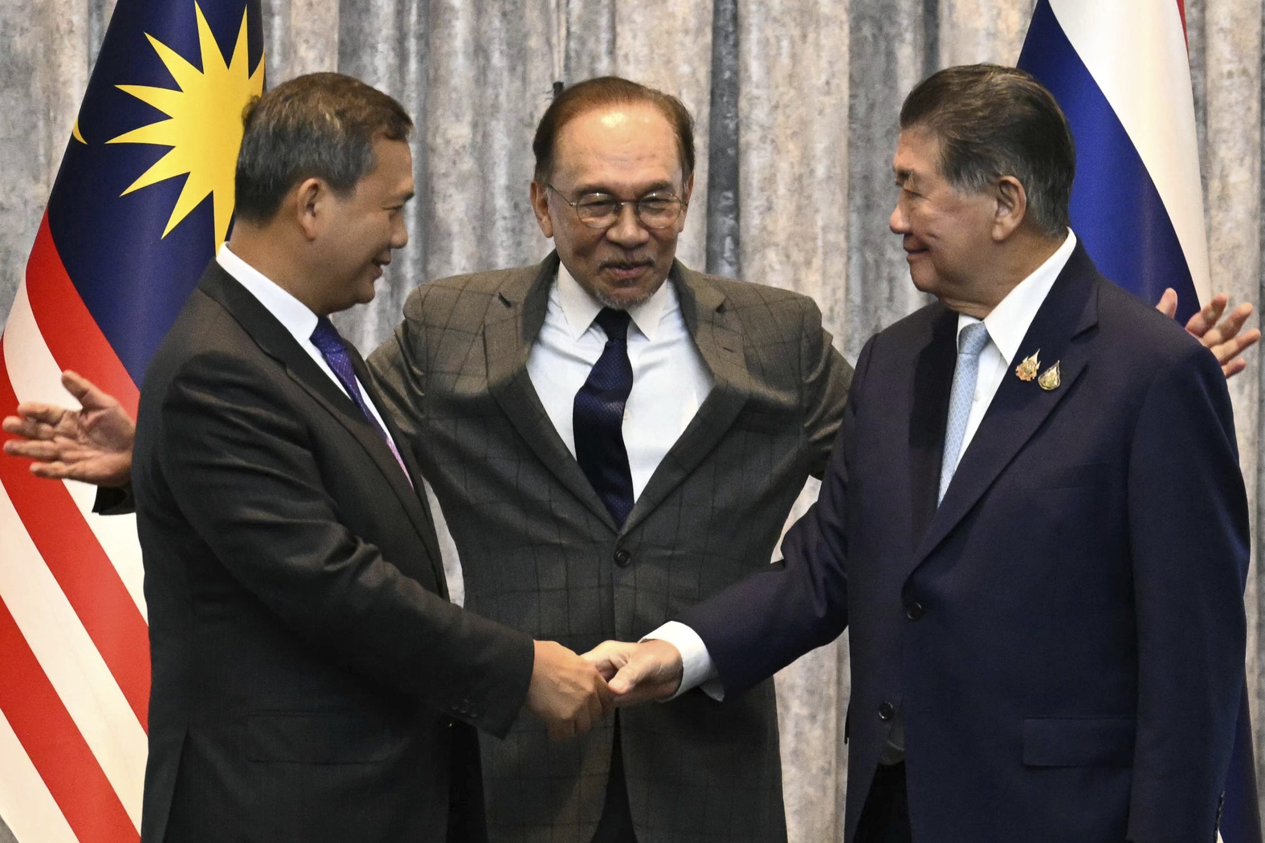 El primer ministro camboyano, Hun Manet (izq), y el primer ministro en funciones tailandés, Phumtham Wechayachai (der) sellan el alto el fuego con la mediación del líder malayo Anwar Ibrahim