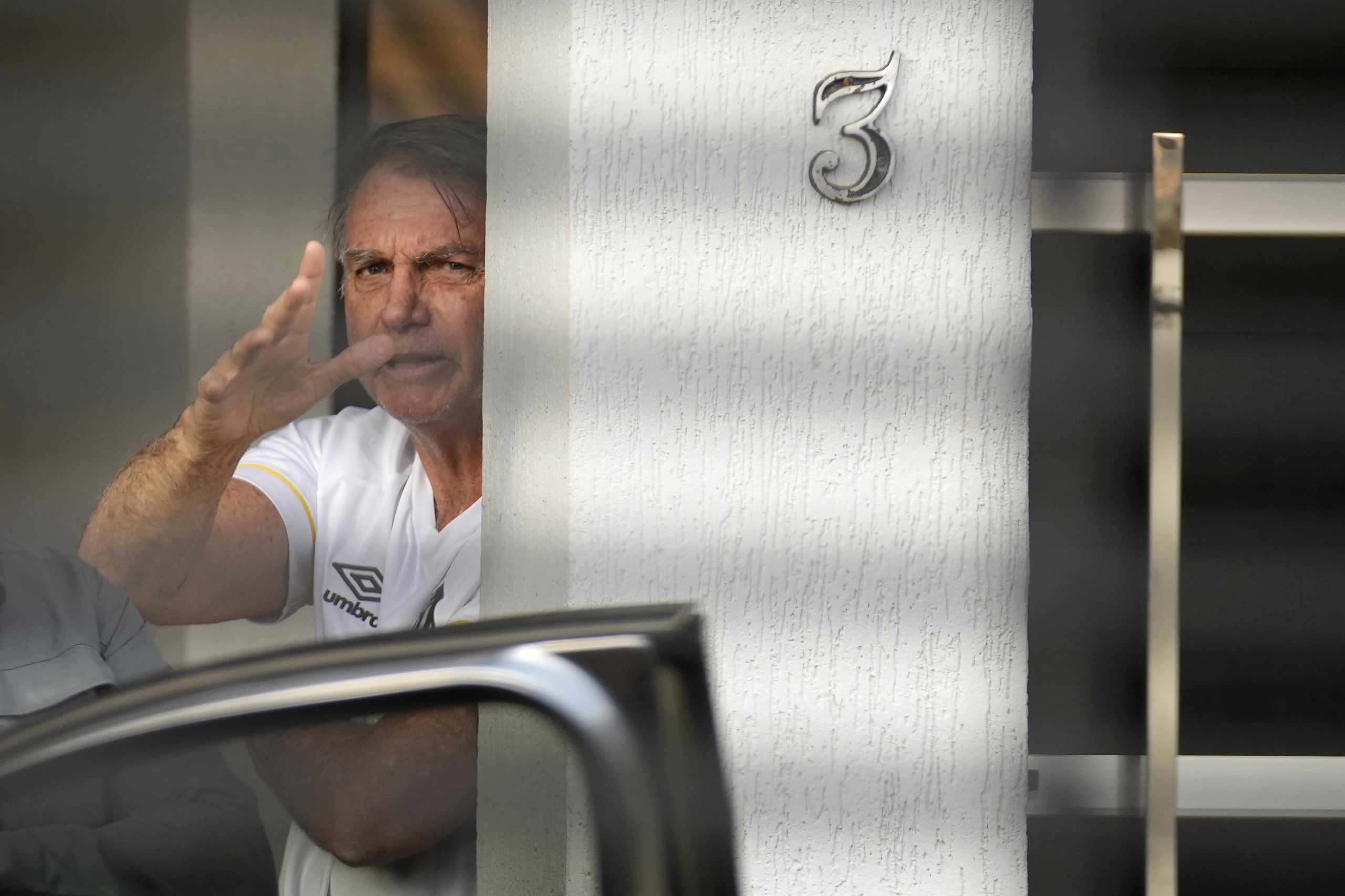 El expresidente de Brasil, Jair Bolsonaro, hace gestos desde la entrada de su domicilio, donde se encuentra bajo arresto domiciliario en Brasilia, Brasil, el viernes 29 de agosto de 2025