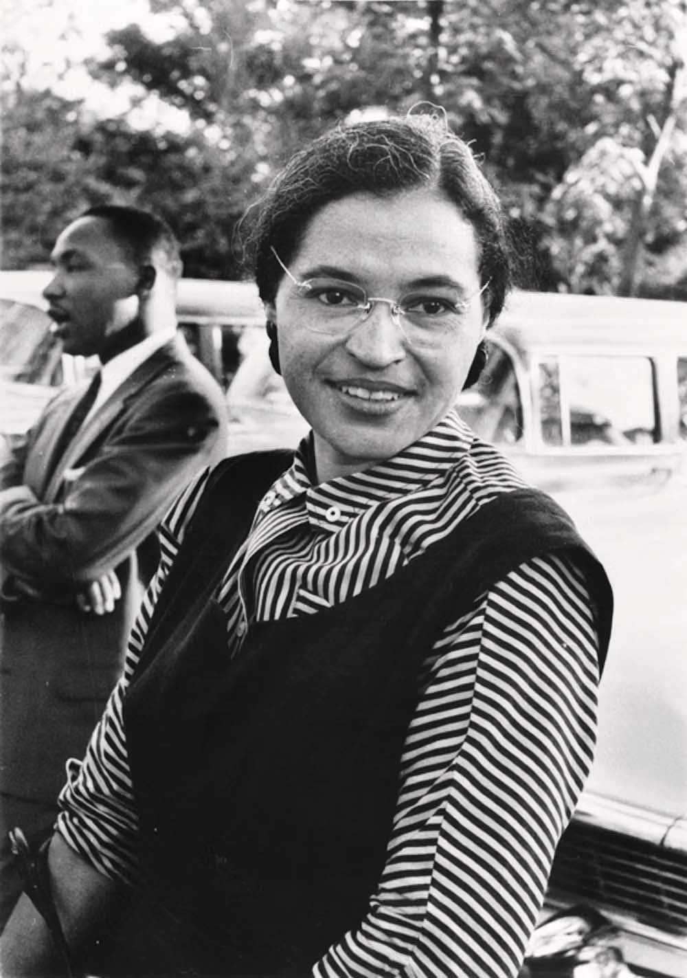 Rosa Parks. Detras de ella, Martin Luther King.