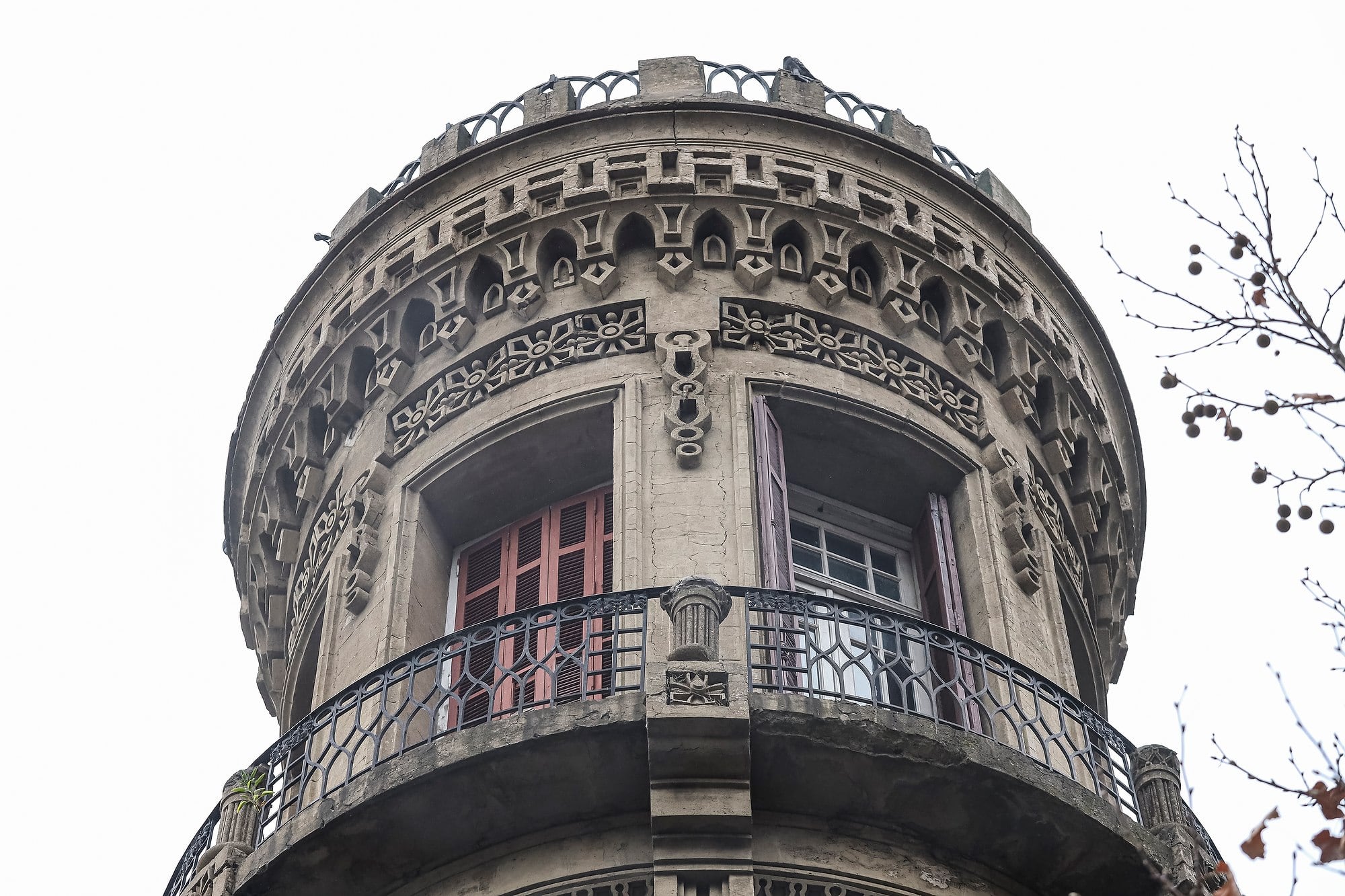 El torreón almenado remite a castillos medievales, con ladrillo visto, ventanas ojivales y detalles ornamentales con elementos góticos