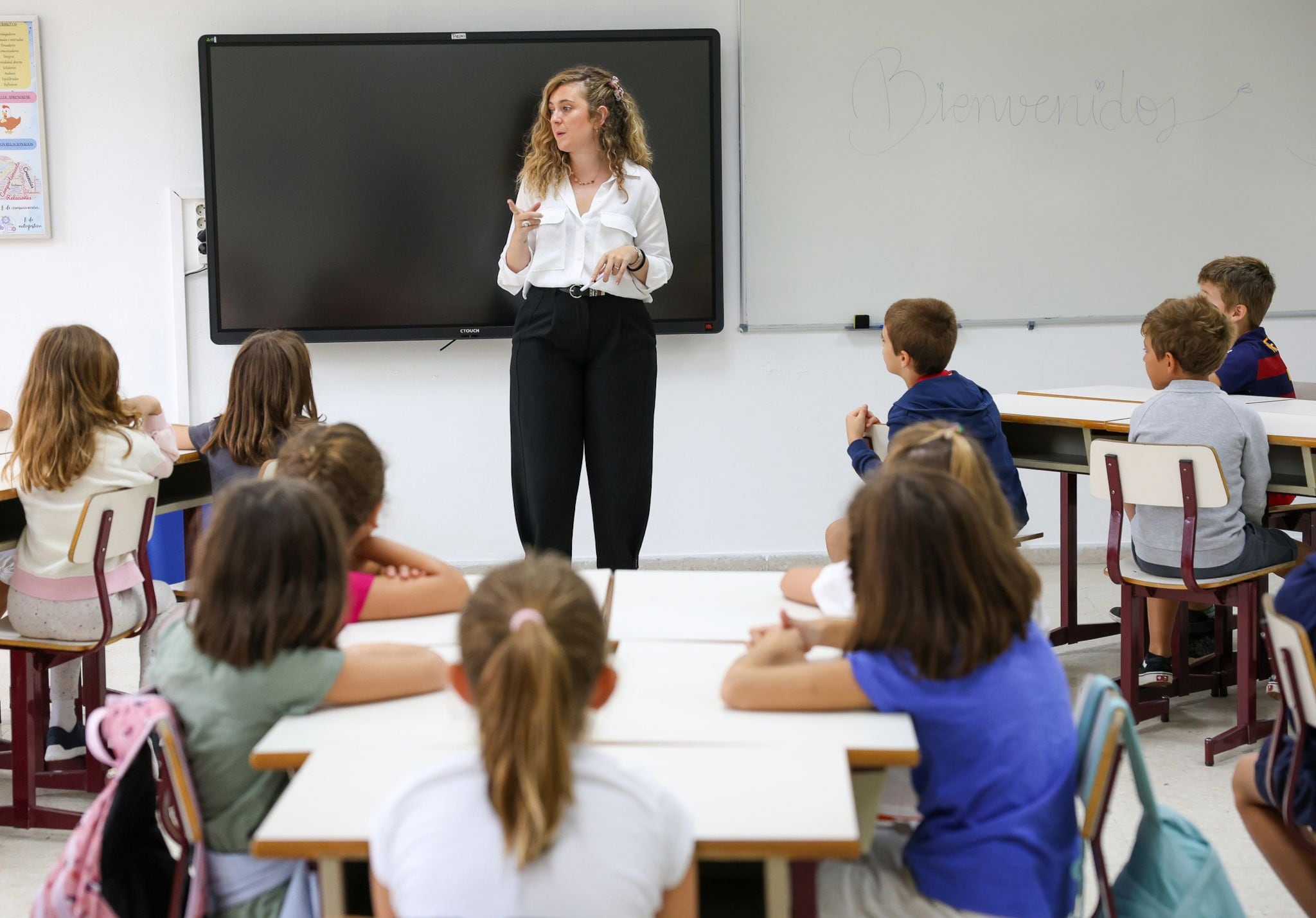 06/09/2023 La profesora y varios alumnos en un aula del colegio Arturo Soria, el primer día de curso escolar, a 6 de septiembre de 2023, en Madrid (España). La Comunidad de Madrid comienza hoy el curso escolar 2023/2024 con 2.000 profesores más que el curso pasado, hasta llegar a los 63.041, así como con récord de alumnos de 0 a 3 años y de Formación Profesional. A esta cifra de profesores en colegios públicos se suman otros 25.653 docentes de colegios concertados, aumentando el número total de profesores en centros sostenidos con fondos públicos a los 88.694. Por otro lado, durante este nuevo curso las clases se inician con 1.261.750 alumnos, un 1,2% más que el curso anterior, de los cuales 684.627 acuden a centros públicos, que registran el mayor incremento. ECONOMIA Marta Fernández Jara - Europa Press