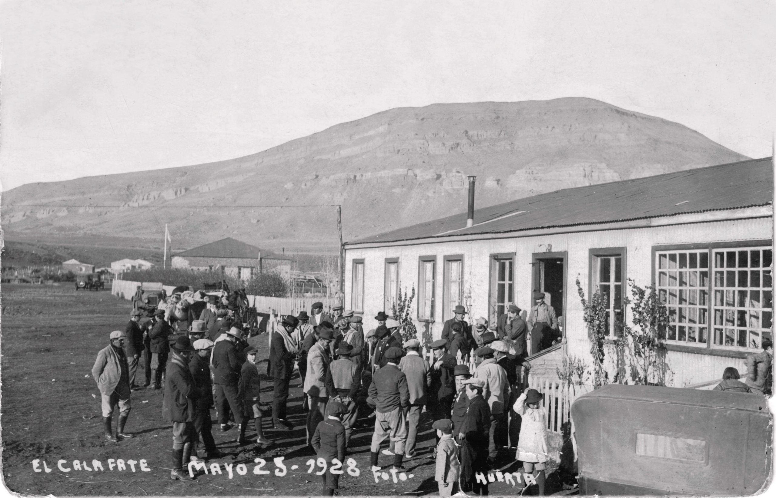 Primer 25 de Mayo luego de la creación formal del pueblo. Retratado por el fotógrafo de Río Gallegos, César Huerta, en el hotel de la familia Pantin Freile. Detrás se ve la comisaría construida por los pobladores y cedida al Estado.