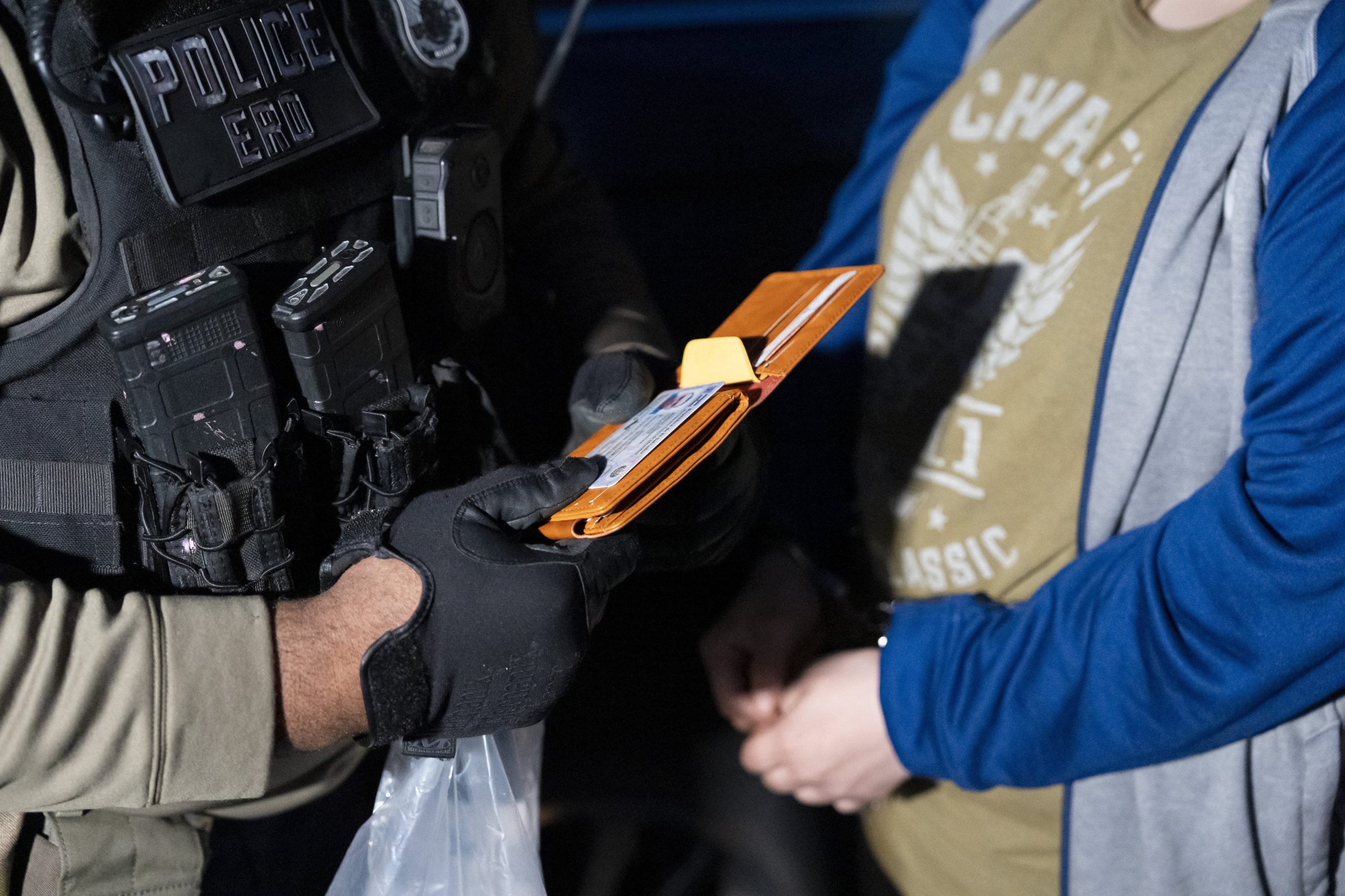 Un agente del Servicio de Control de Inmigración y Aduanas (ICE) revisa los documentos de un detenido (AP Photo/Alex Brandon)