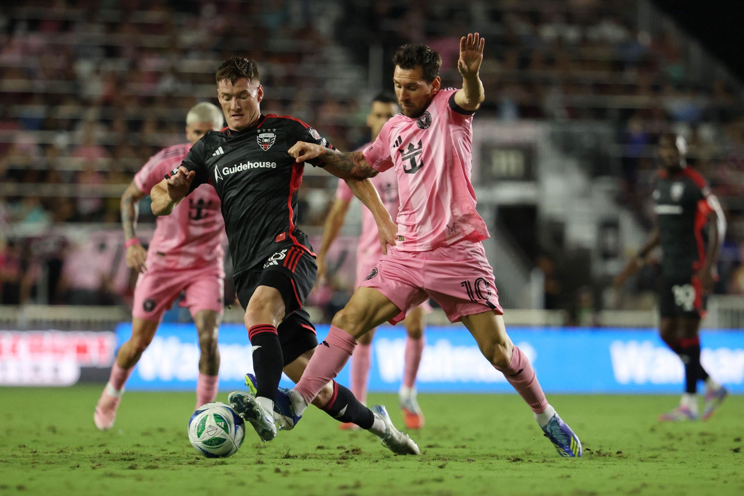 David Schnegg, de DC United, lucha por la pelota con Lionel Messi